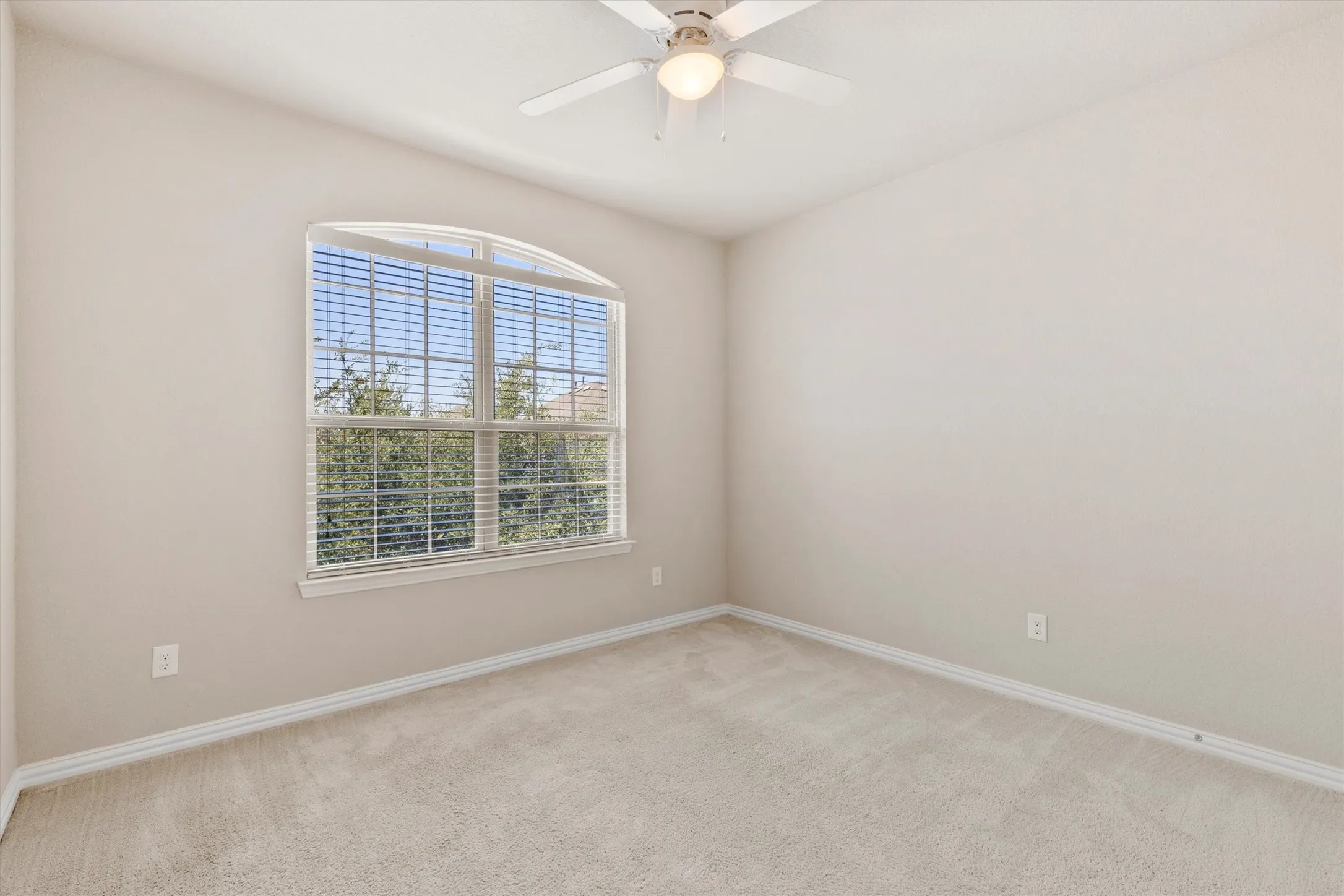 Open-concept living area featuring wood-finish flooring, a tray ceiling with a ceiling fan, and recessed lighting