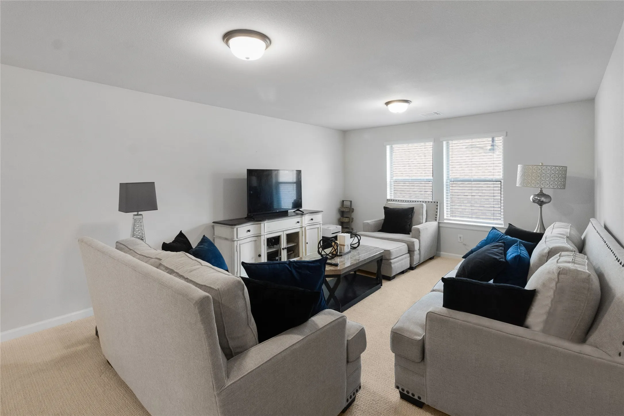 Spacious living area featuring neutral carpeting and light-toned walls
