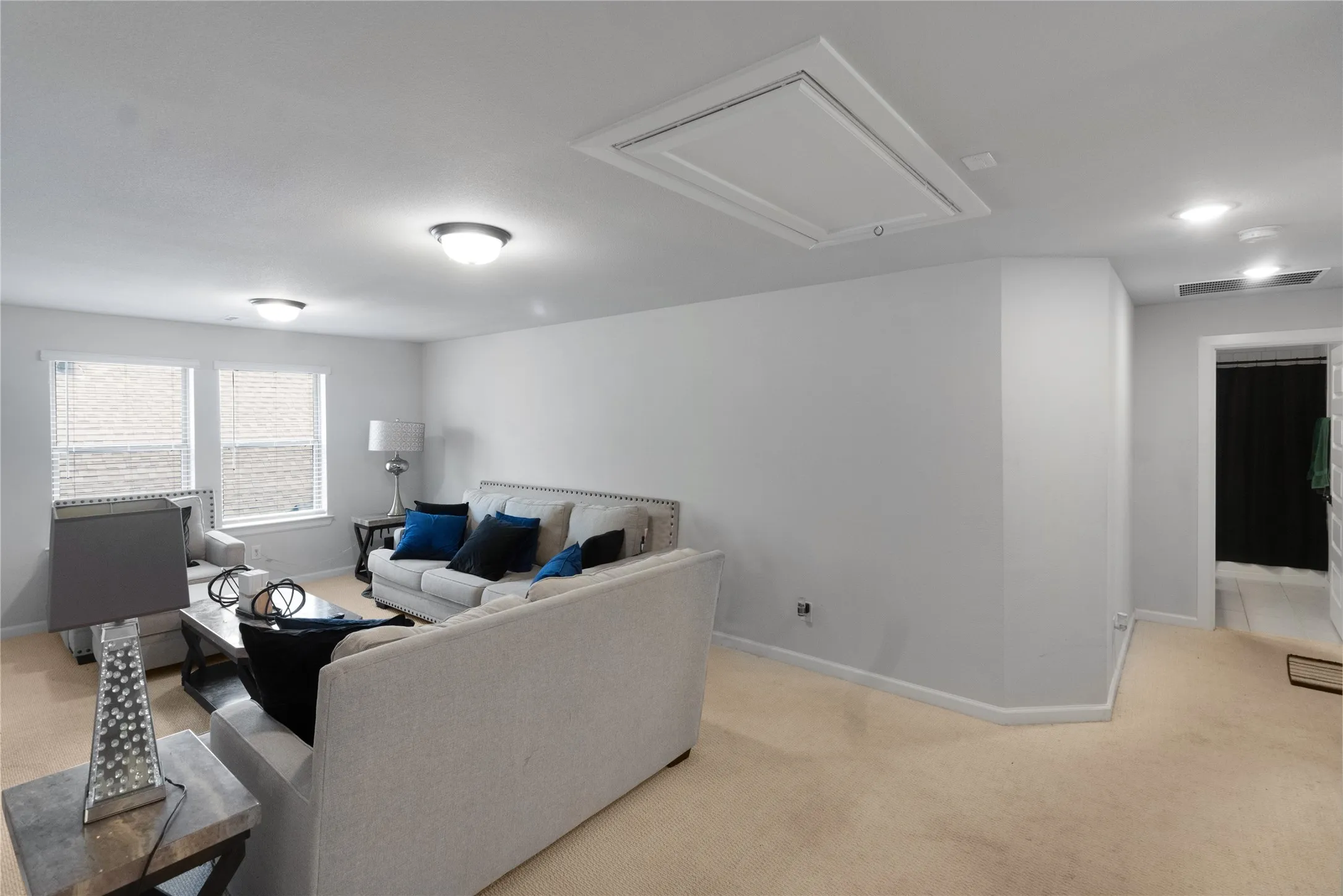Spacious bonus room featuring neutral carpeting, recessed lighting, and dual windows with blinds