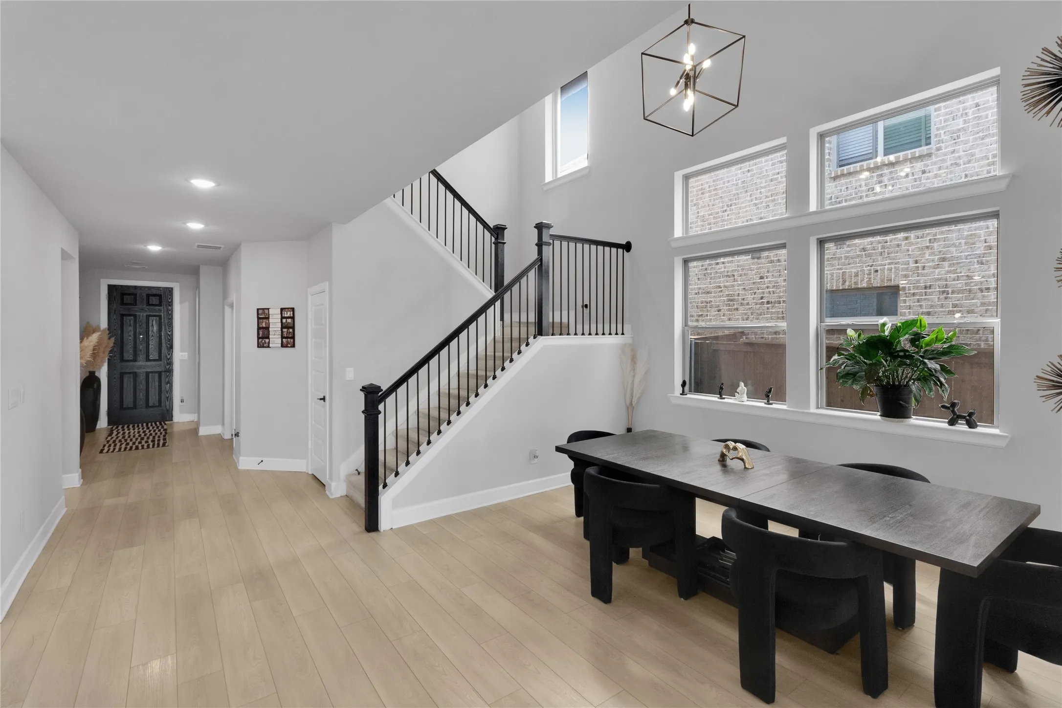 Two-story entryway featuring light wood-finish flooring and recessed lighting