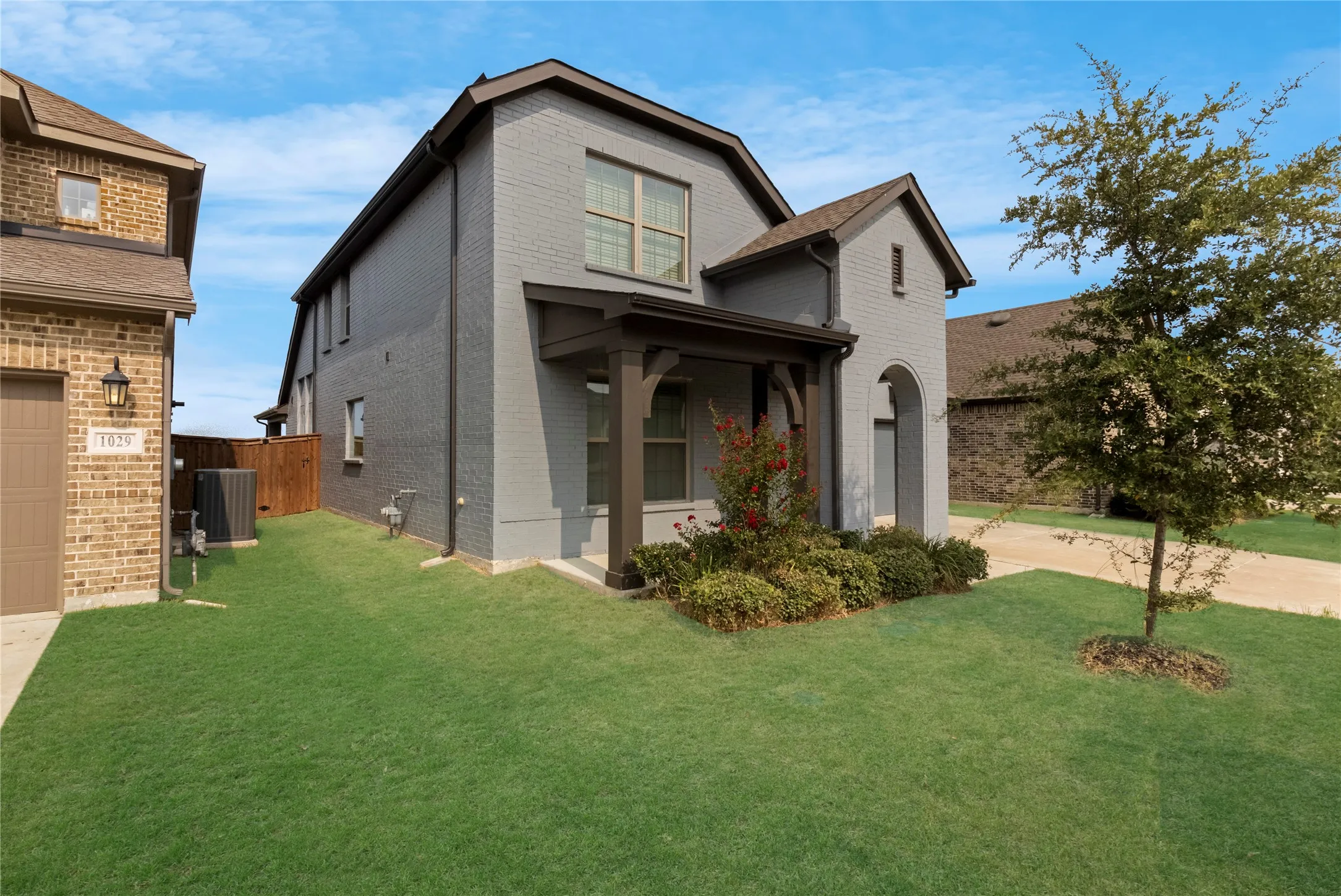 Modern two-story home featuring a striking charcoal and gray exterior with architectural barn-style roofline