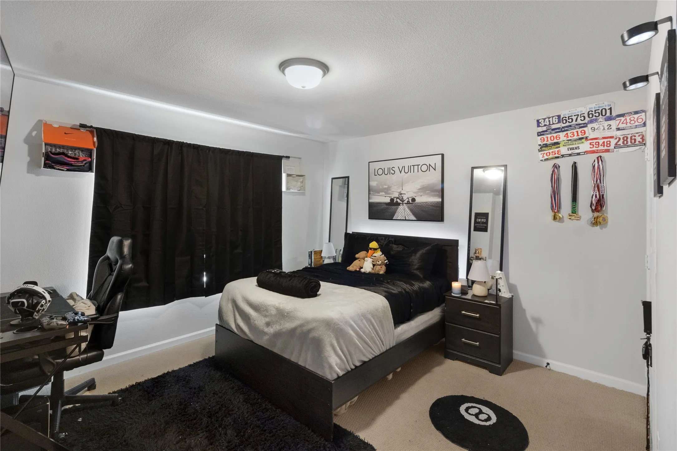 Bedroom featuring light beige carpeting, white walls, and a ceiling-mounted light fixture