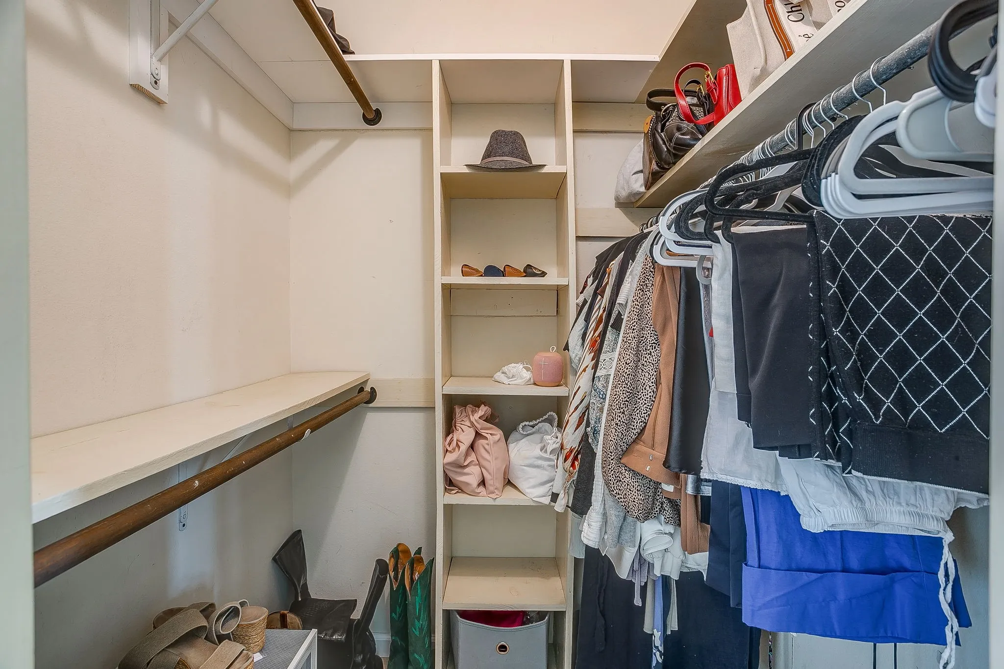 Custom closet organization system featuring built-in shelving and multiple hanging rods