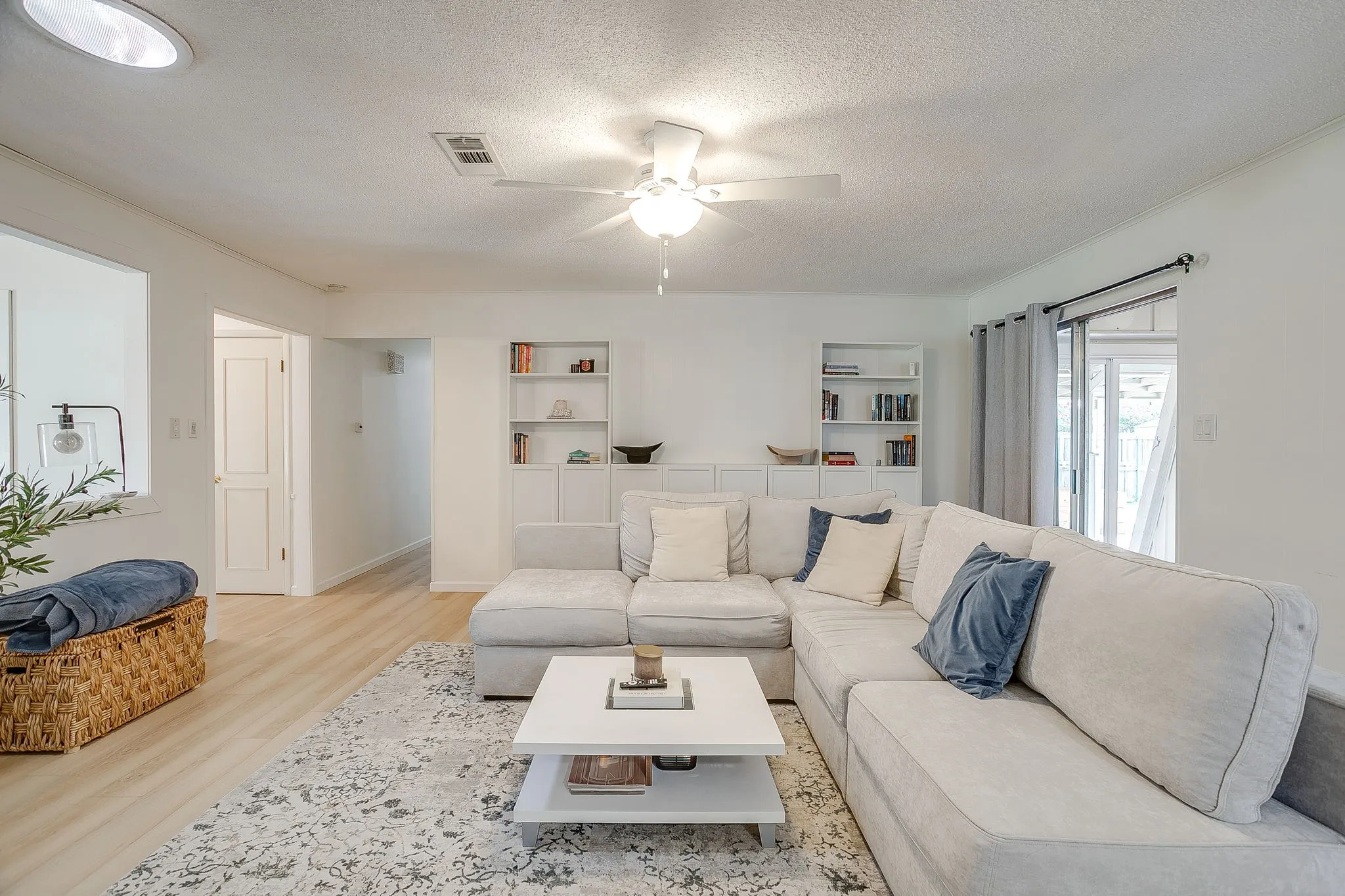 Recessed ceiling light, ceiling fan, wood-finish flooring, built-in shelving, and sliding glass door