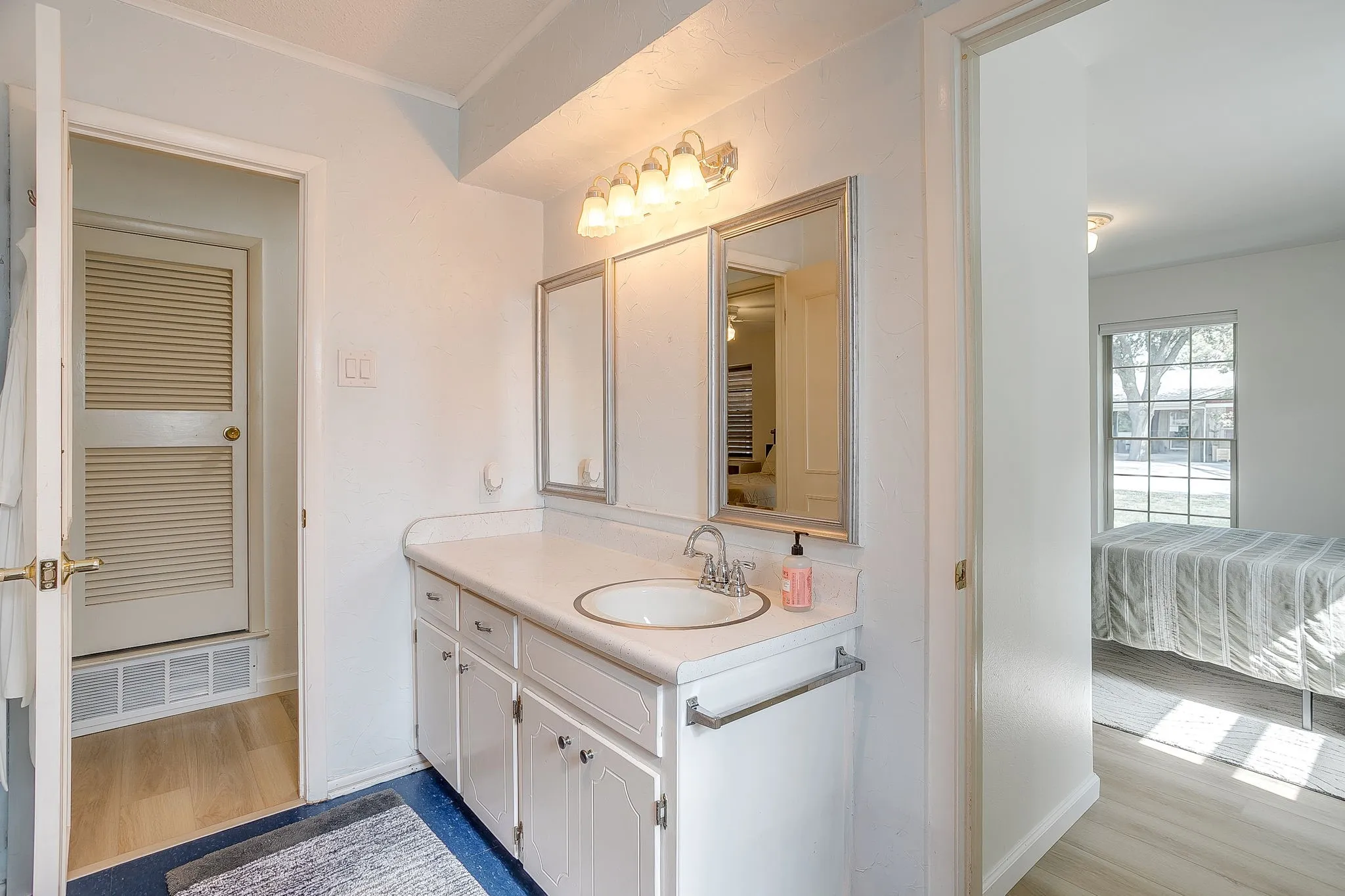Vanity featuring an integrated sink, laminate countertop, and framed mirrors