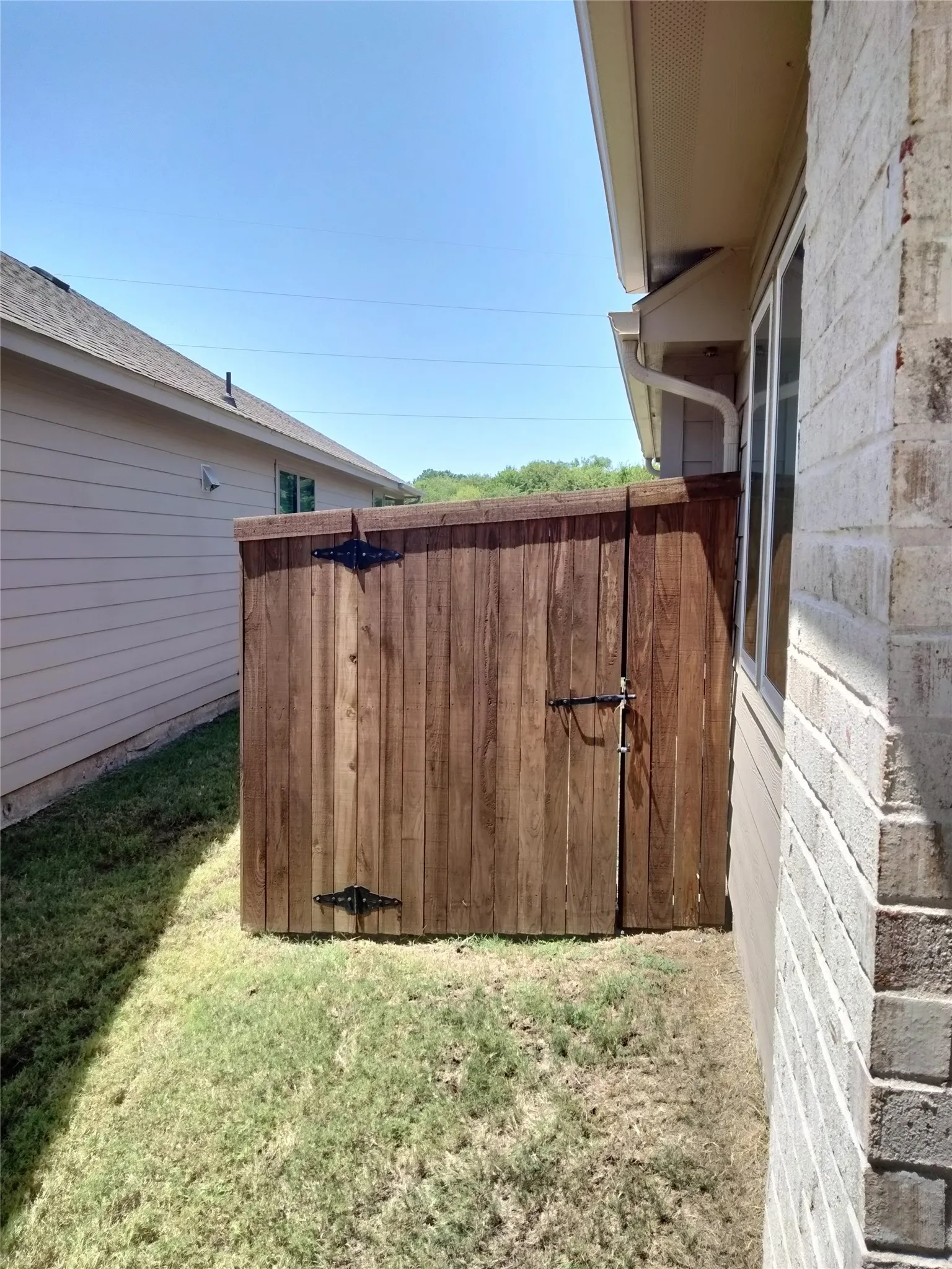 Wood-paneled privacy fence with decorative iron hardware