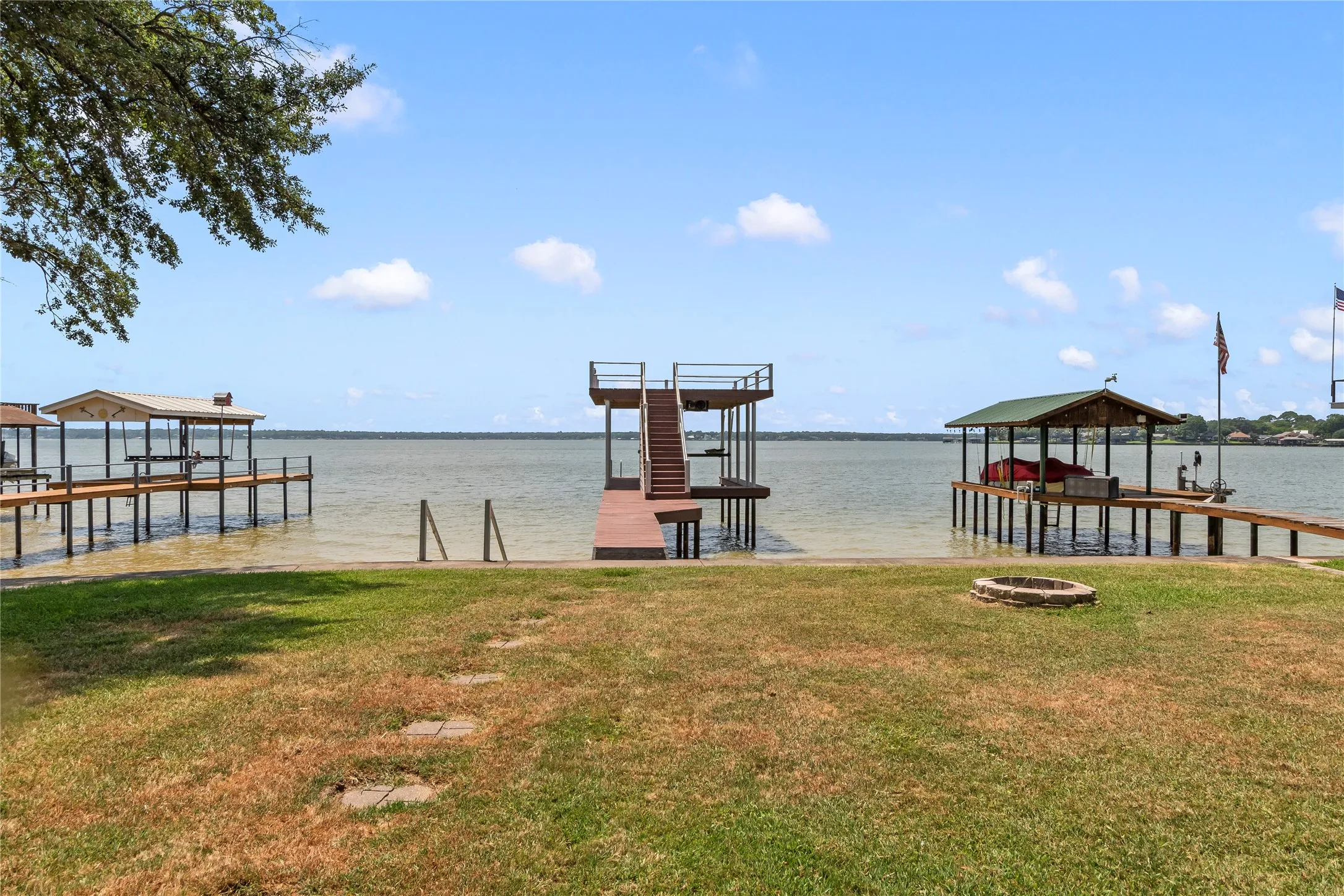 Boathouse featuring a boat slip with lift and spacious party deck.