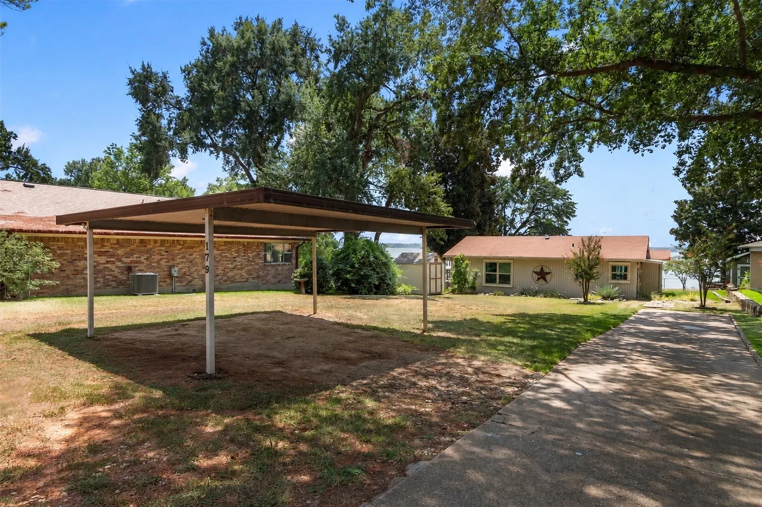 Front of home showcasing a spacious front yard and two-car carport.