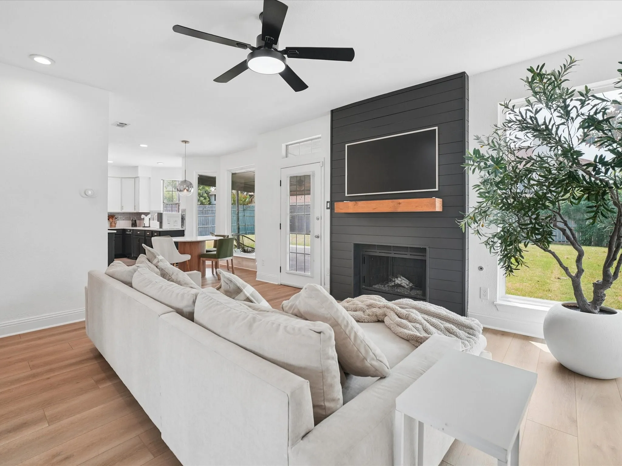 Living area with wood-finish flooring, a contemporary ceiling fan, and recessed lighting