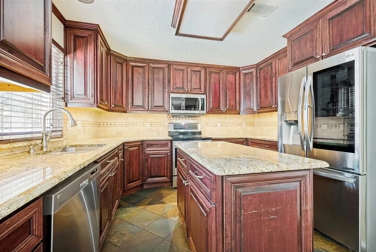 Beautifully remodeled kitchen featuring abundant counter space for meal prep and an oversized island providing additional workspace, seating, and the perfect gathering spot for family and friends.