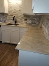 White shaker-style cabinetry with top-tier Dekton countertops and a textured tile backsplash