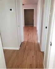 Wood-finish flooring throughout, white walls, and white trim
