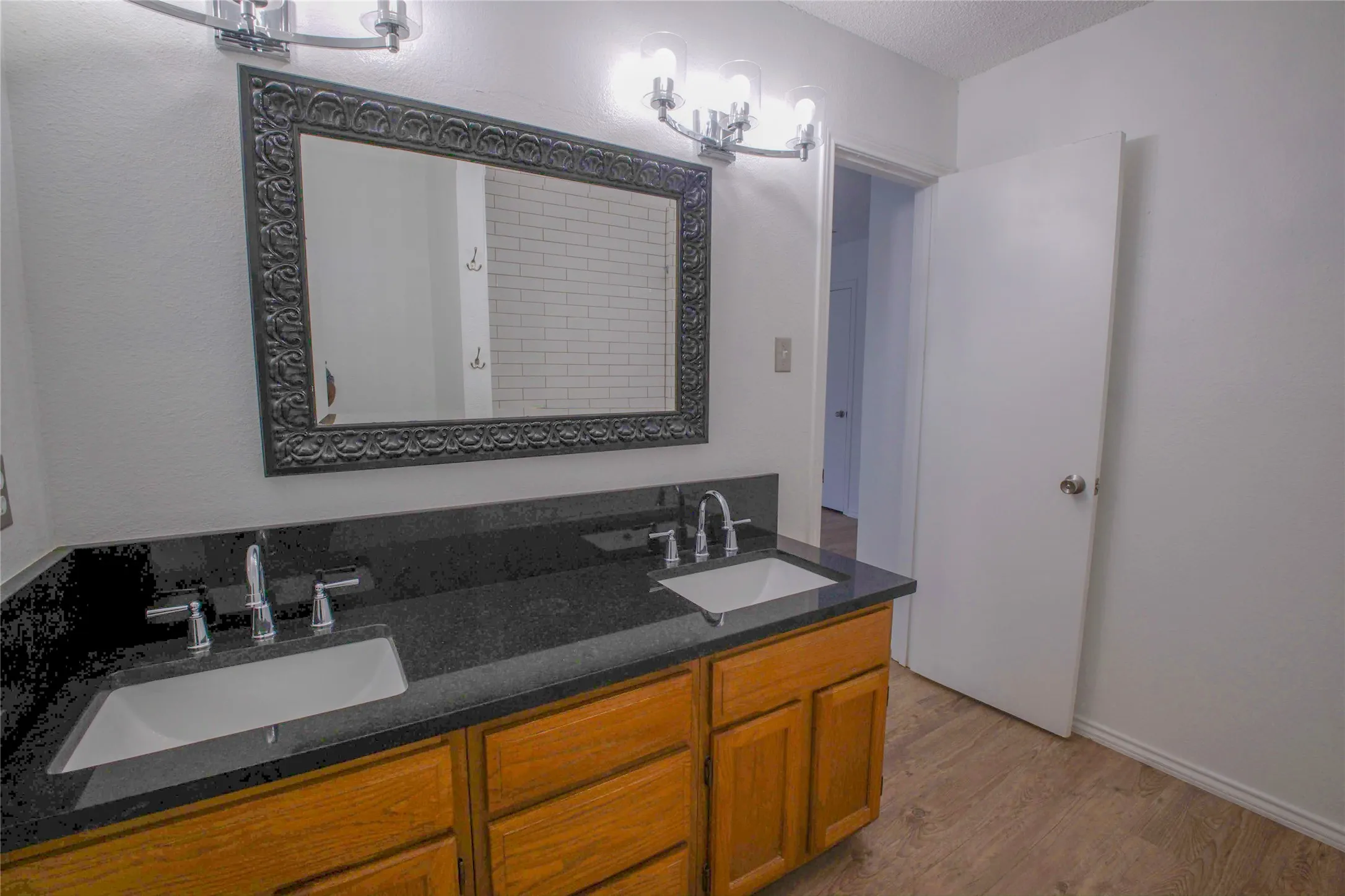 Dual vanity with dark stone countertop and integrated sinks