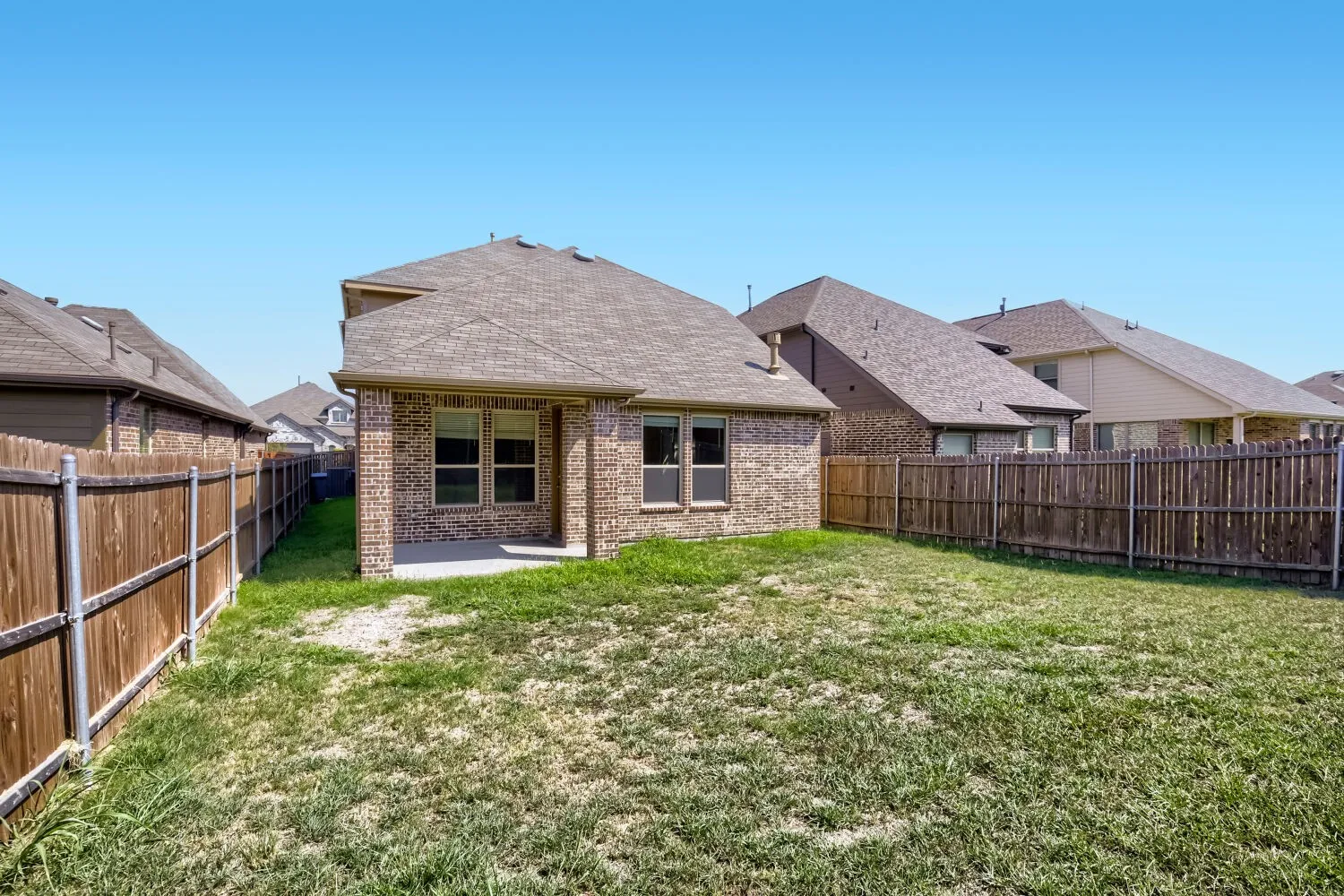 Expansive backyard with a covered patio and full privacy fencing