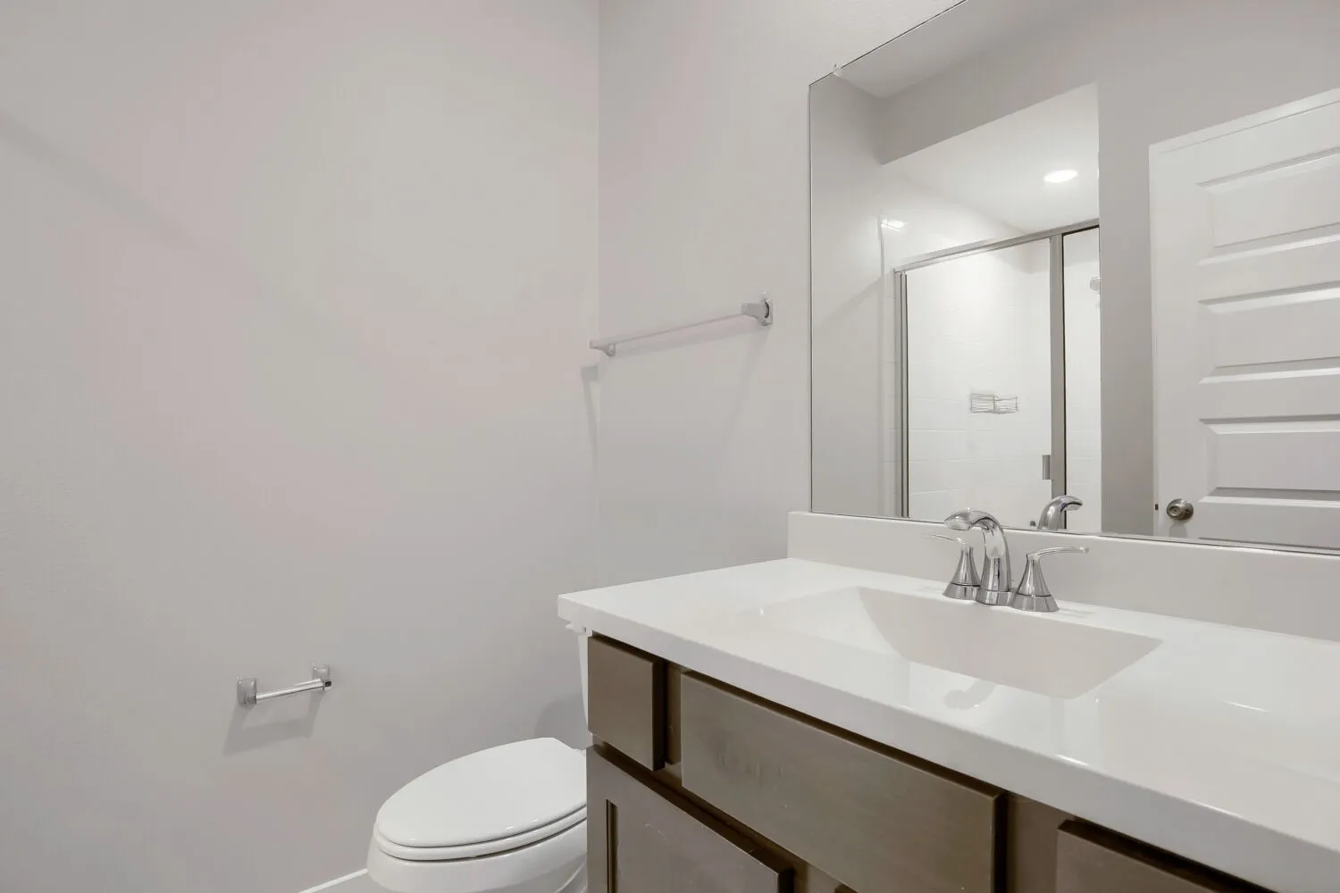 Bathroom featuring a vanity with an integrated sink, polished chrome faucet, and a large mirror
