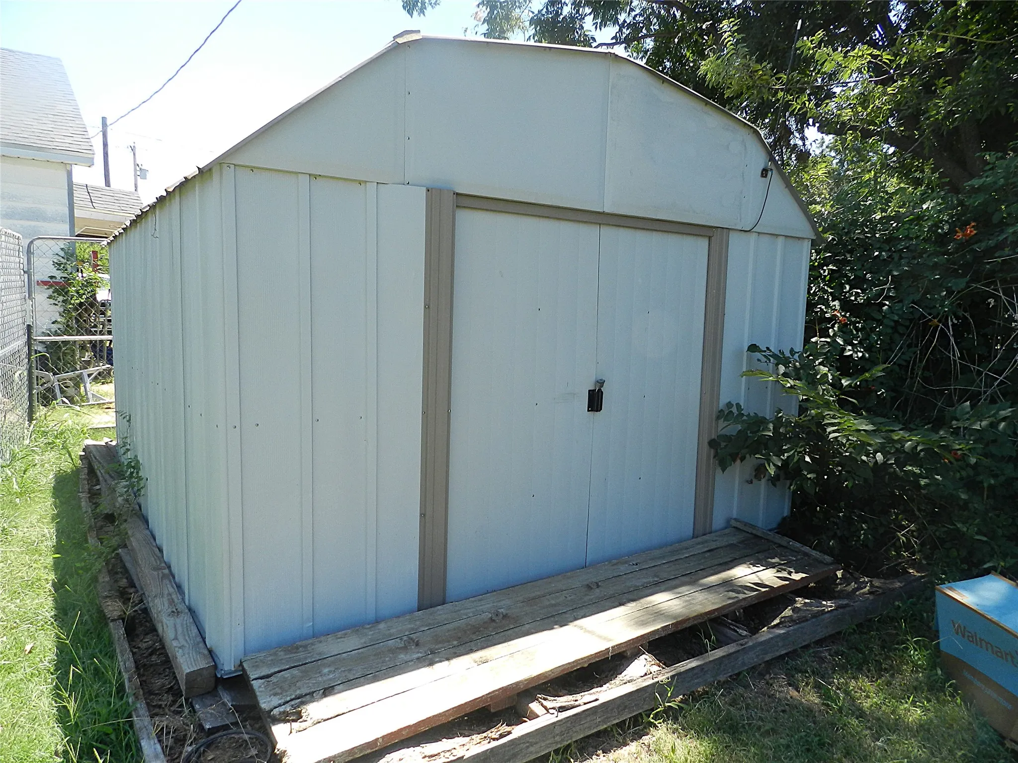 White metal storage shed with a curved roofline