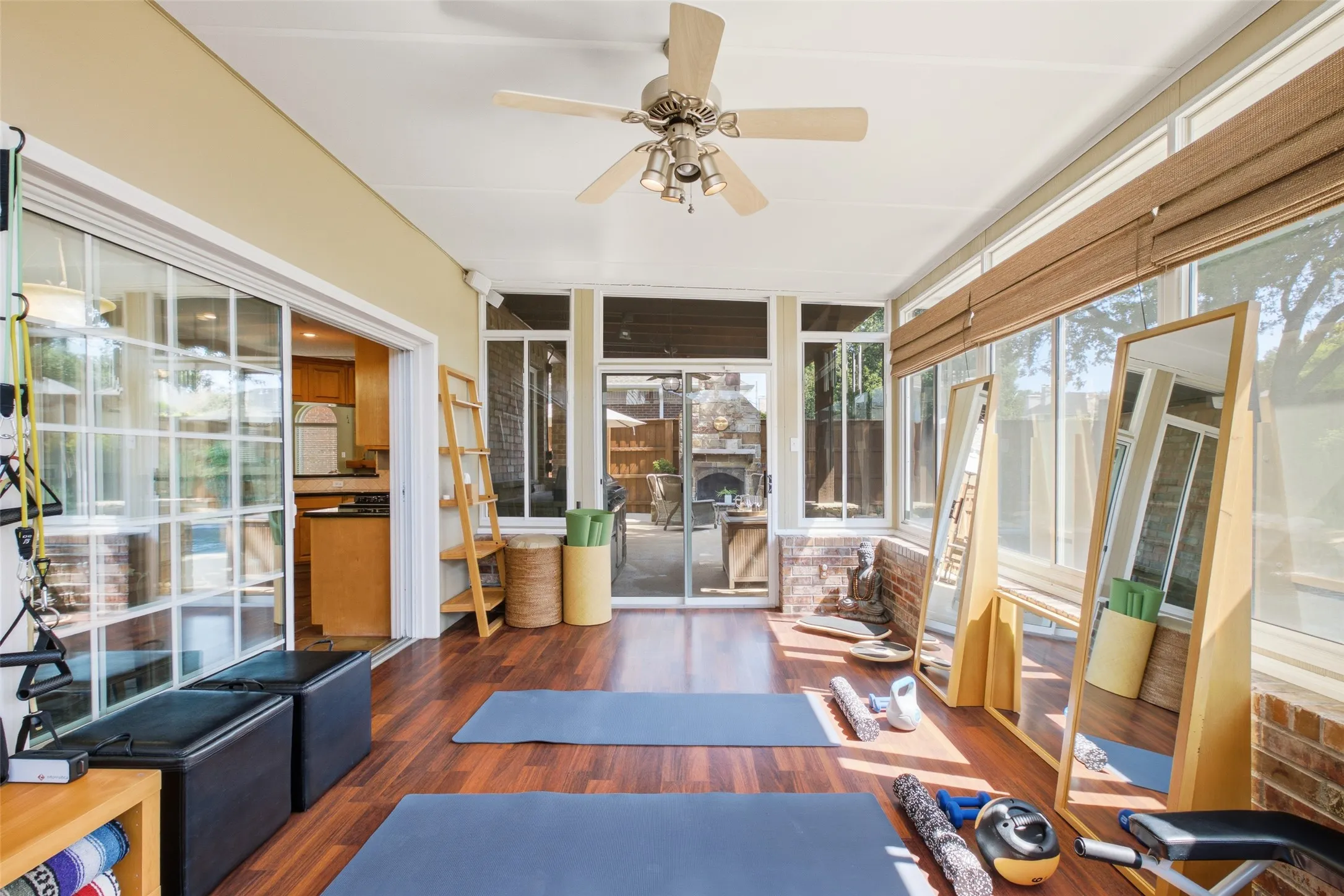 Light-filled sunroom with panoramic views of the backyard and patio, hardwood floors, and direct access to both the kitchen and outdoor living areas.