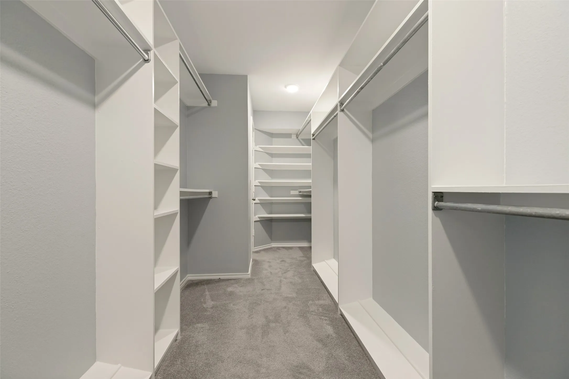 This impressive 17x6 walk-in closet sits directly inside the primary bathroom, offering exceptional convenience and a true suite-style experience. The built-in shelving and multiple hanging areas provide abundant storage space, keeping everything organized and easily accessible. The light, neutral finishes and bright lighting make the closet feel open and inviting, while the thoughtful layout maximizes every inch of space. This closet is a standout feature of the primary ensuite, combining size, functionality, and modern design to create a beautifully efficient dressing area.