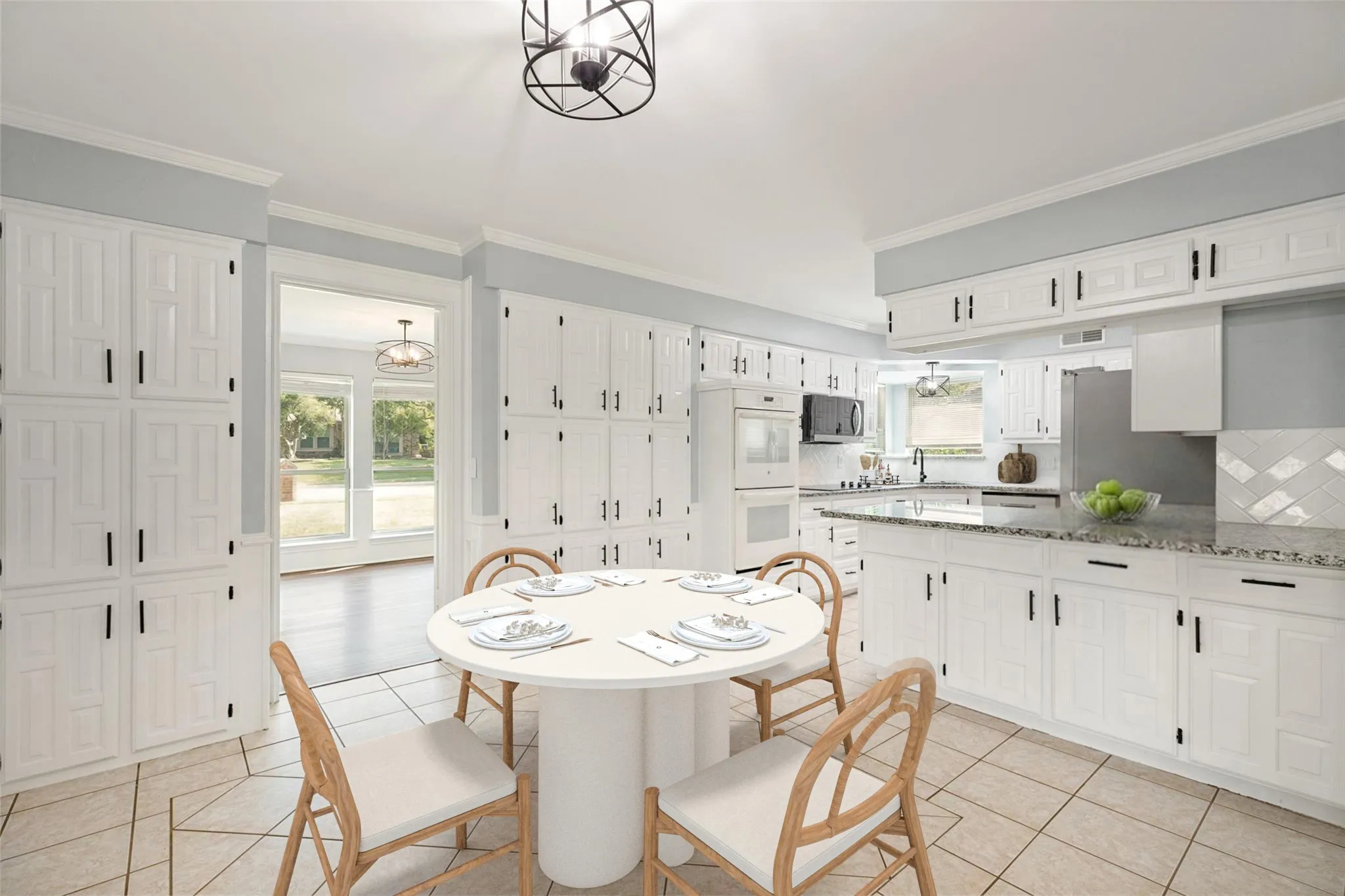 This beautiful kitchen features expansive white cabinetry with sleek black hardware, offering abundant storage and a clean, modern aesthetic. The granite countertops provide generous workspace, complemented by a stylish diagonal tile backsplash that adds texture and visual interest. Stainless steel appliances, including the built-in oven, microwave, and refrigerator, elevate the space with a polished, contemporary feel. The geometric tile flooring enhances the room’s brightness and ties the design together with a warm, cohesive look. Overhead, the black metal light fixture adds a touch of modern character, while the open sightline into the adjacent room keeps the kitchen feeling connected and inviting.