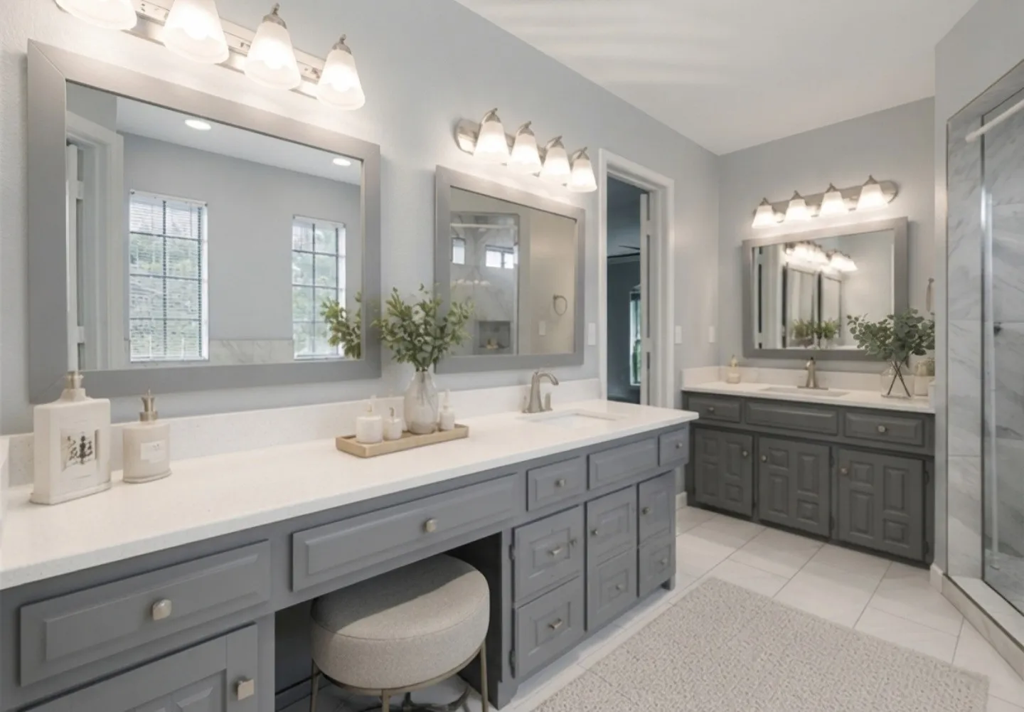 This additional view of the primary bathroom highlights just how large and spacious the ensuite truly is. The dual vanities create a beautifully symmetrical layout, each featuring its own framed mirror and lighting, making the space feel bright, open, and exceptionally functional. The abundance of mirrors throughout enhances natural light and makes getting ready with ease an everyday luxury. The glass-enclosed shower with windows and cohesive finishes continue the room’s modern, elegant aesthetic, reinforcing the bathroom’s thoughtful design and generous proportions.