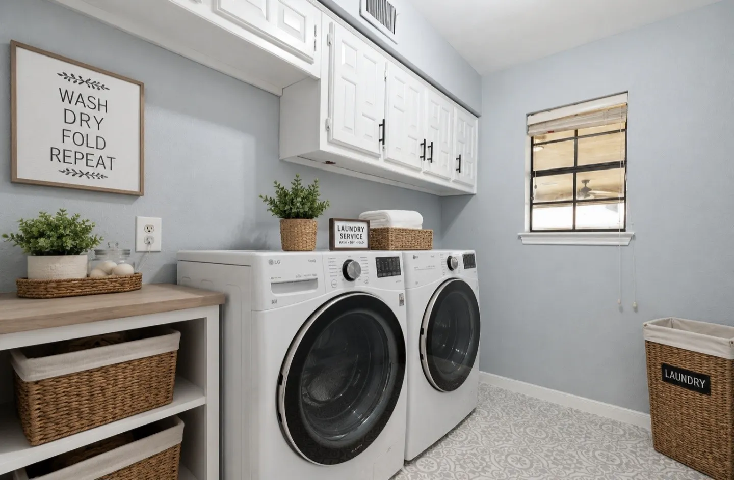 This spacious laundry room offers exceptional convenience with its large layout and abundant upper cabinetry, providing plenty of storage for detergents, linens, and household essentials. A well-placed window brings in natural light, making the space feel bright and comfortable while laundry is being done. The dedicated washer and dryer connections are thoughtfully arranged for easy access, and the clean, modern finishes create a fresh, organized environment. Designed for efficiency and everyday ease, this laundry room makes household activities enjoyable and effortlessly manageable.
