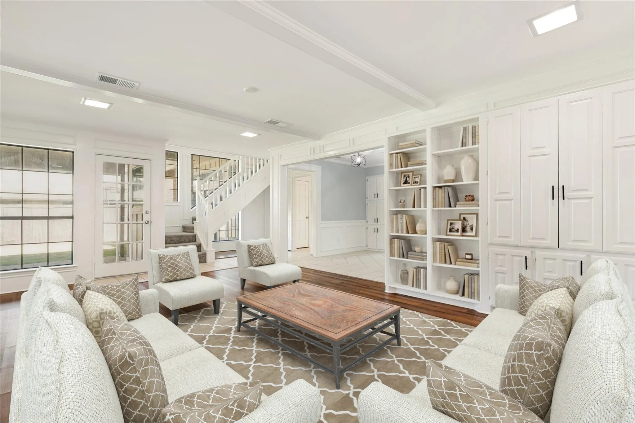 This wonderful space features built-in cabinetry creating a perfect place to display décor or store everyday essentials. Large windows and a glass door bring in abundant natural light and provide a clear view of the backyard, enhancing the room’s bright and open atmosphere. The carpeted staircase creates a graceful transition to the second level, while the wide doorway into the adjoining area highlights the home’s generous layout and easy flow. Every detail in this room reflects care, comfort, and a move-in ready presentation that stands out beautifully.