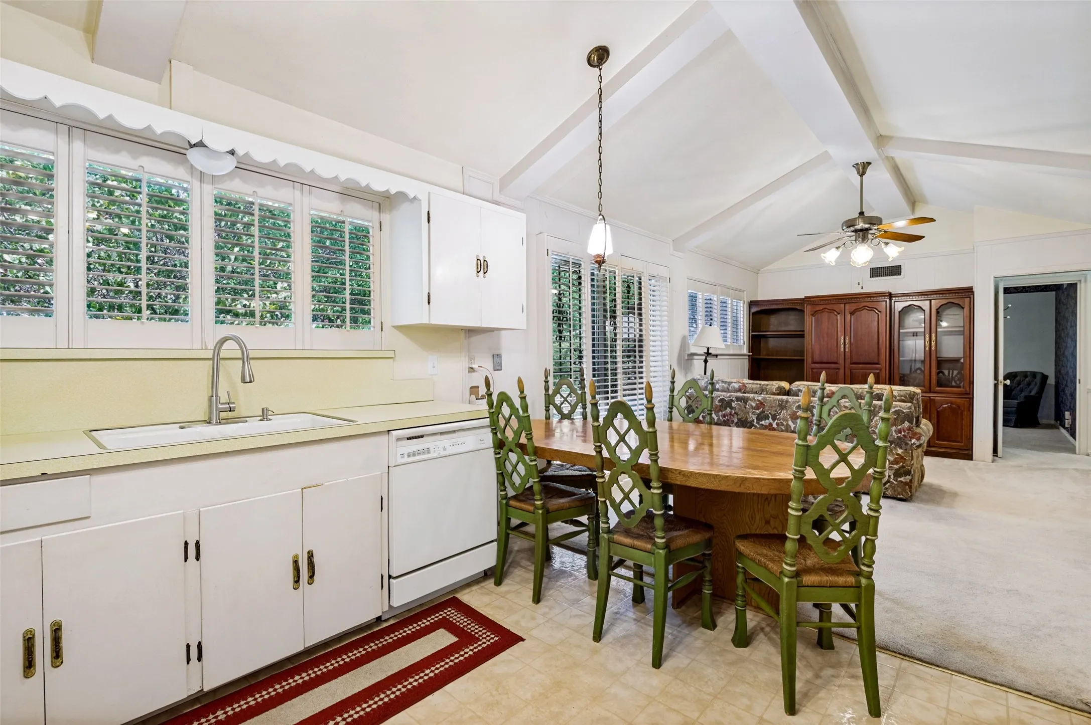 Kitchen area featuring white cabinetry, light-toned countertops, and a stainless steel sink with a modern faucet