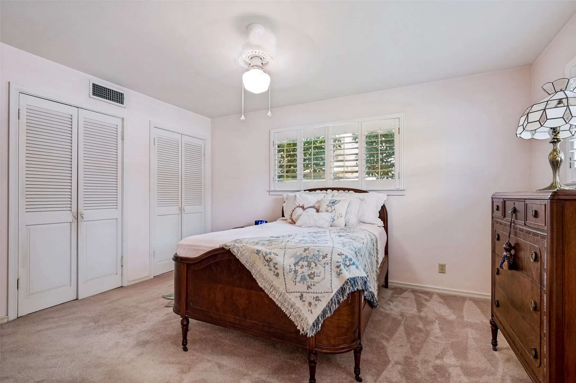 Wall-to-wall carpeting and white louvered bifold closet doors