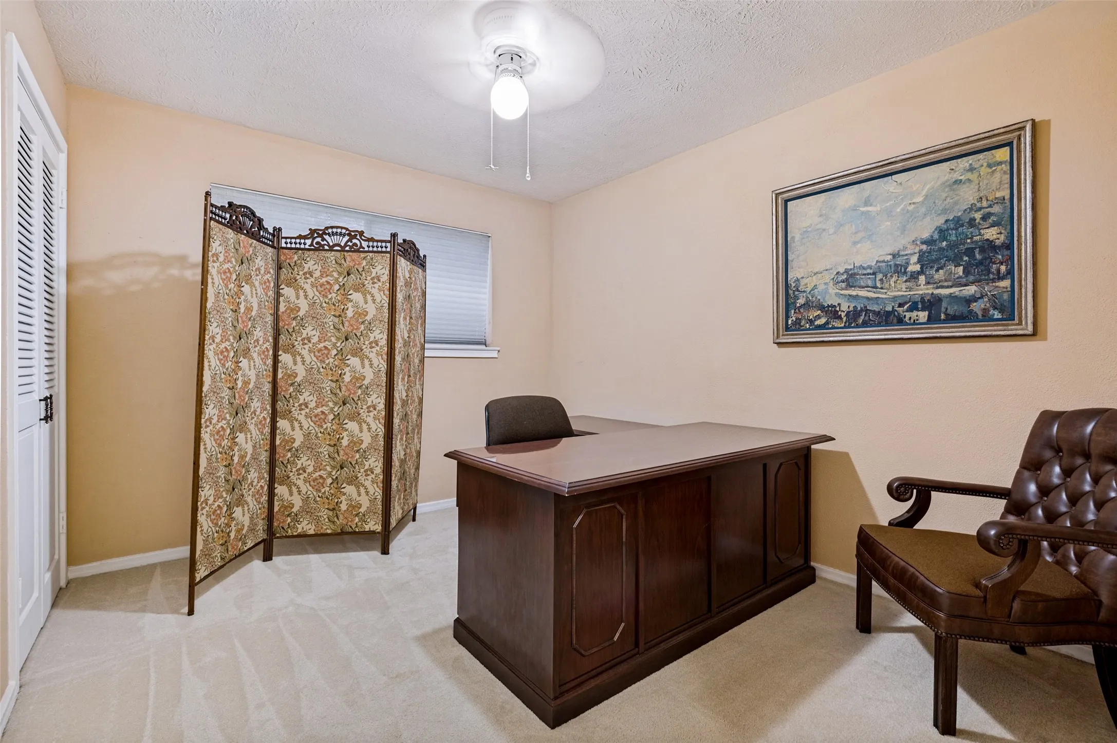 Carpeted interior room with a ceiling-mounted light fixture and a single window