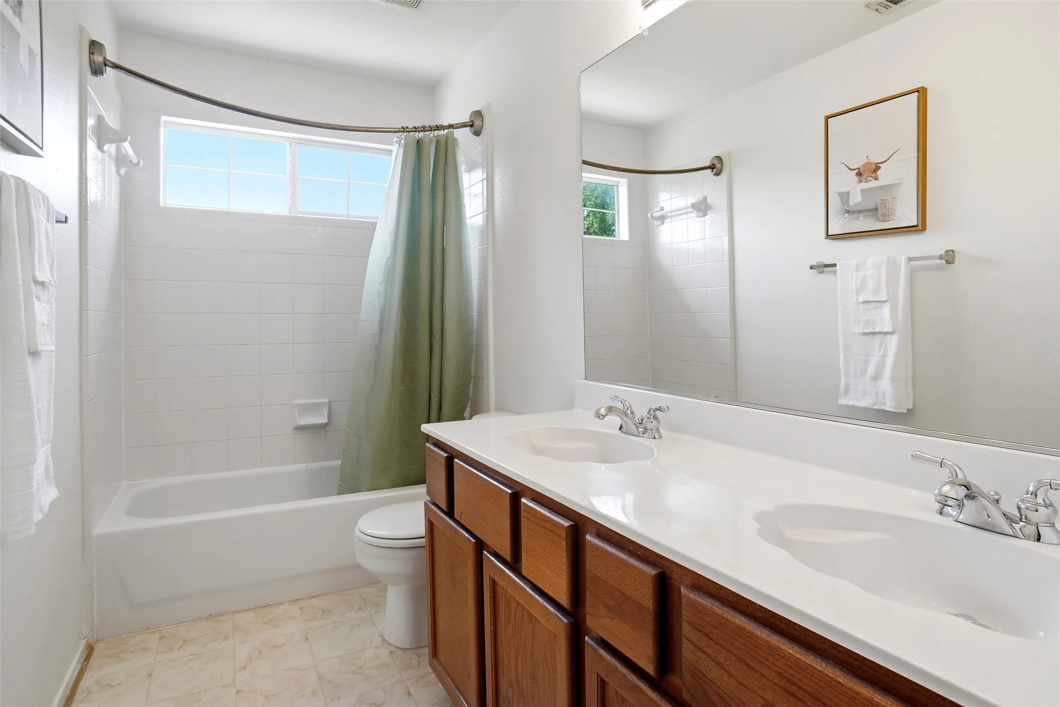 Upstairs full bathroom featuring a dual-sink vanity, tub/shower combination, and plenty of counter and cabinet space.