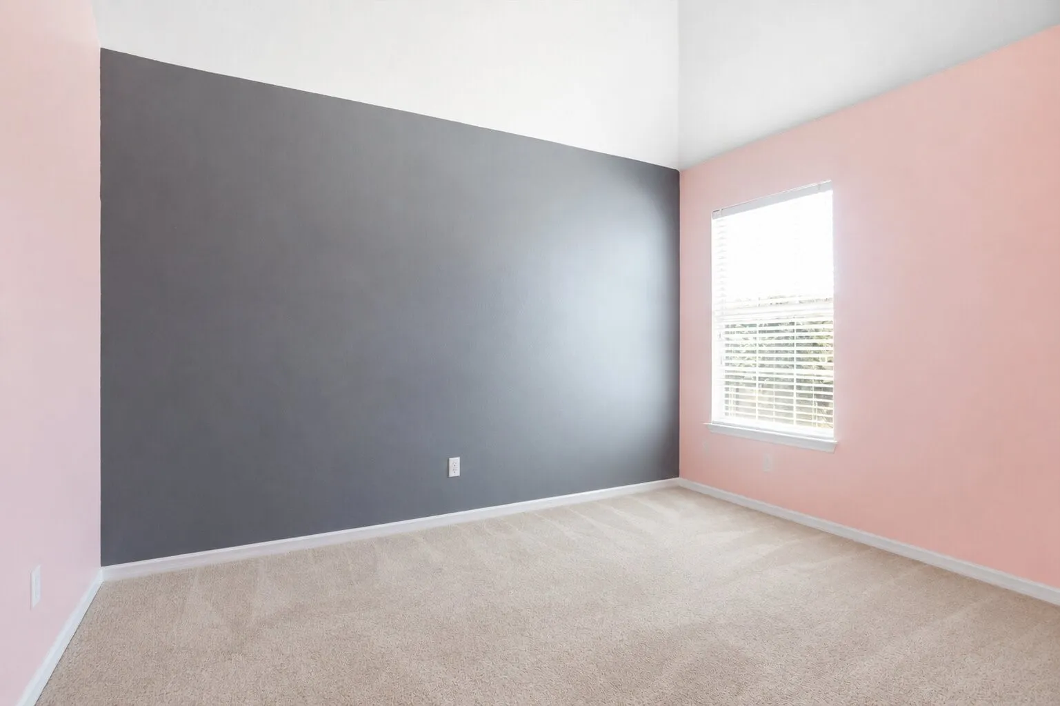 Secondary bedroom featuring a vaulted ceiling, bold accent wall, and abundant natural light.