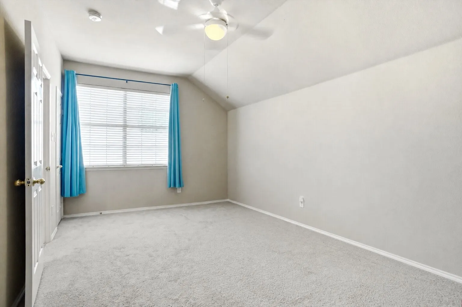 Spacious third secondary bedroom featuring a vaulted ceiling, abundant natural light, and a flexible layout that could also function as a game or media room.