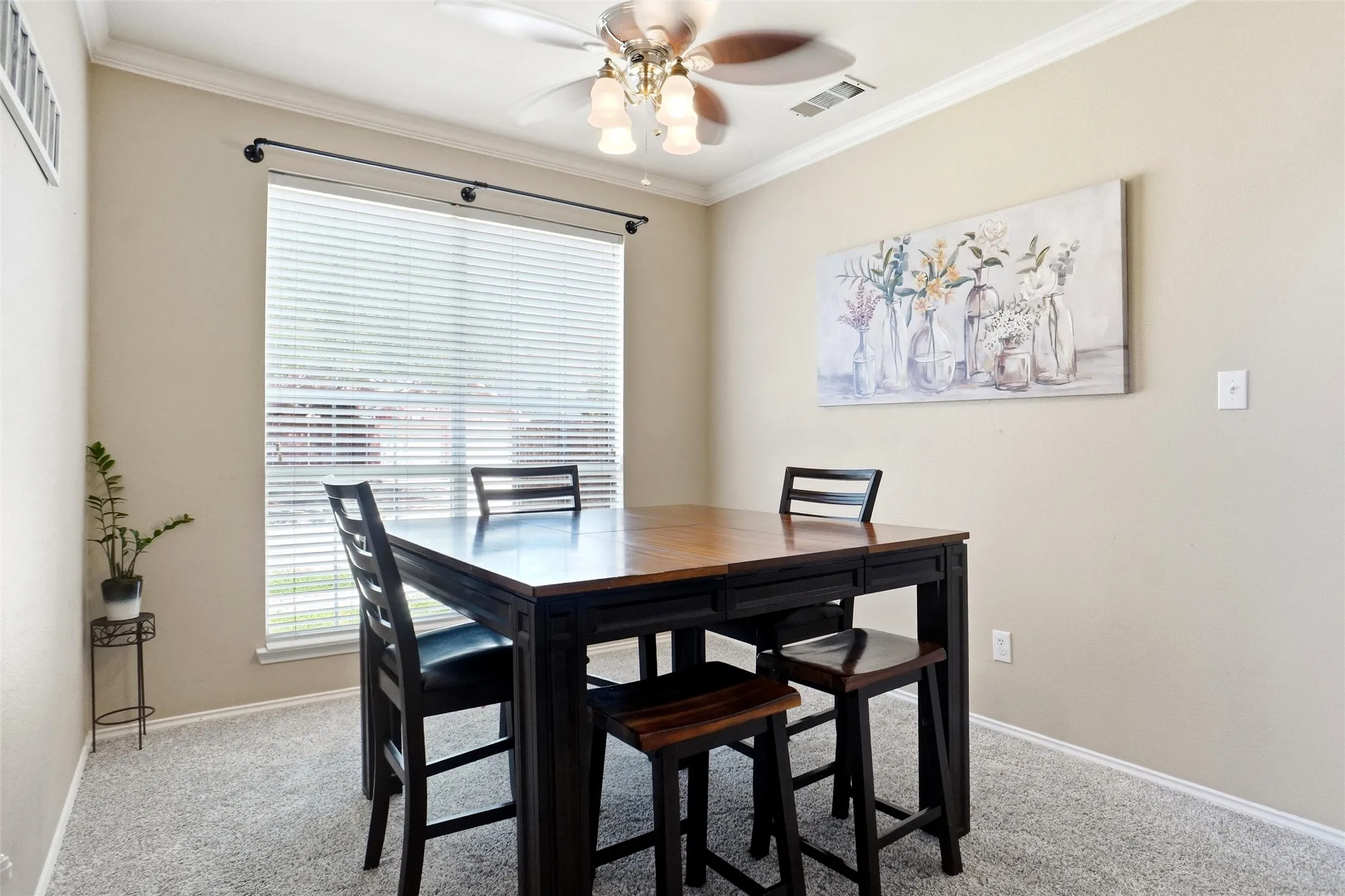 Formal dining room featuring abundant natural light, crown molding, and ample space for everyday meals and gatherings.