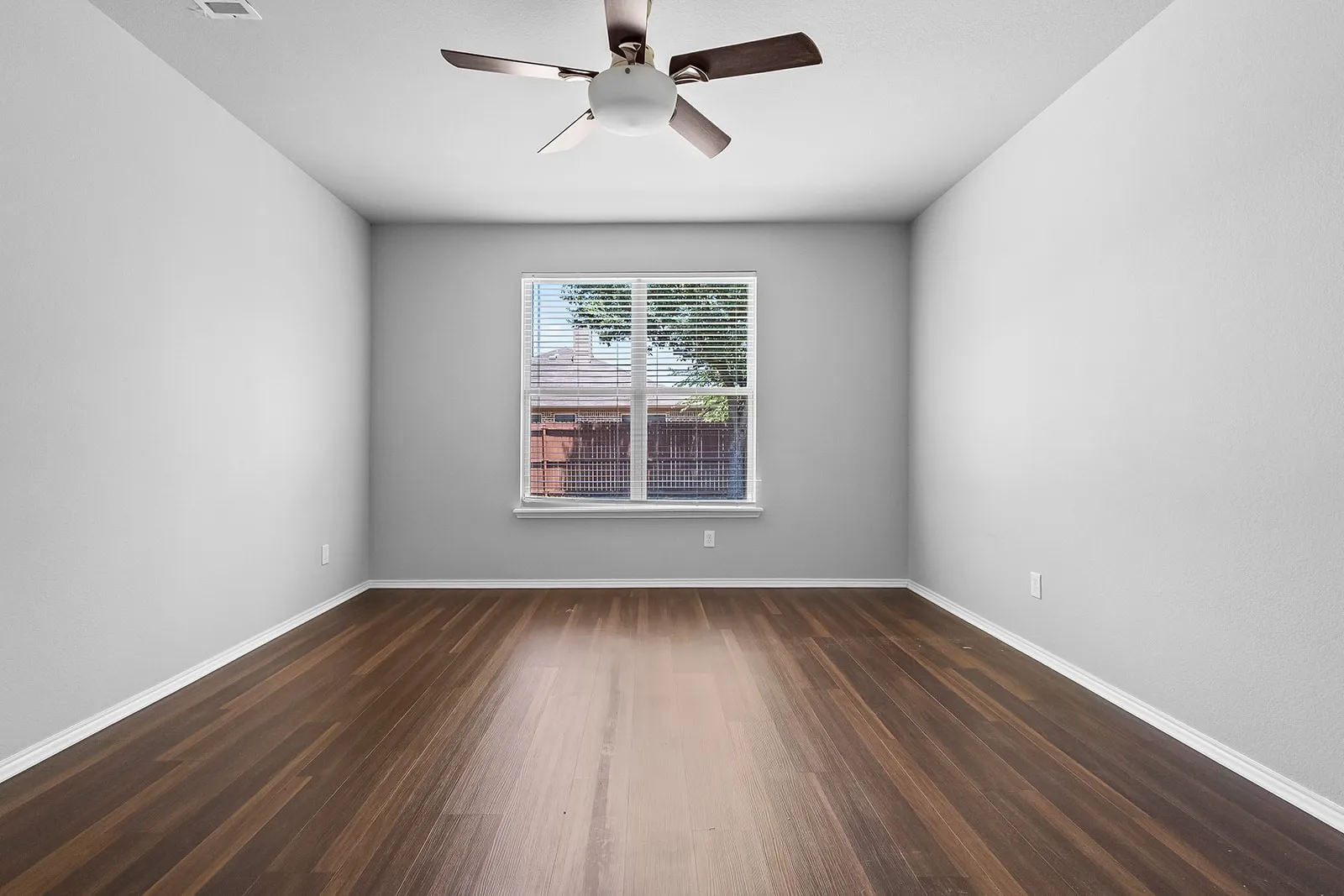 Interior room featuring wood-finish flooring, light gray wall paint, and white baseboards
