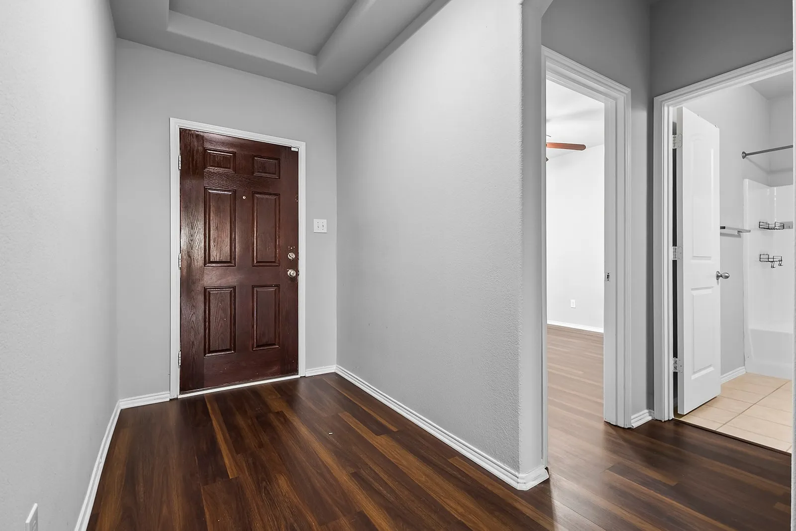 Entryway featuring wood-finish flooring, a paneled door, and neutral wall tones