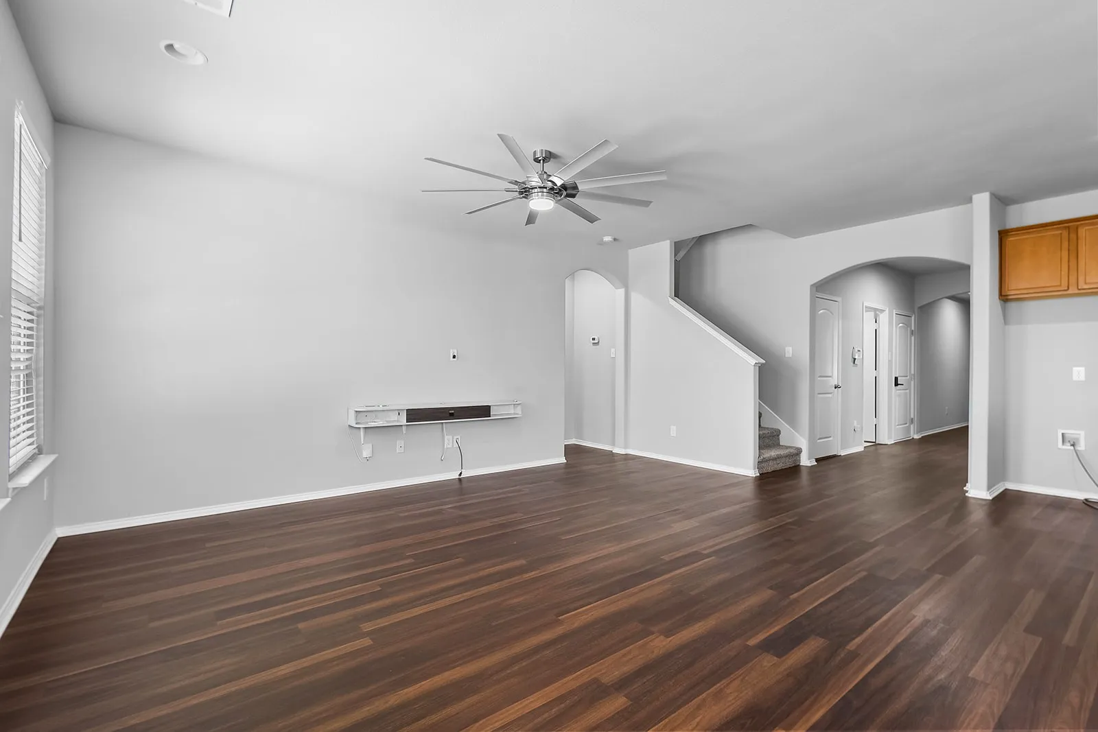 Spacious living area featuring wood-finish flooring, recessed lighting, and a modern ceiling fan