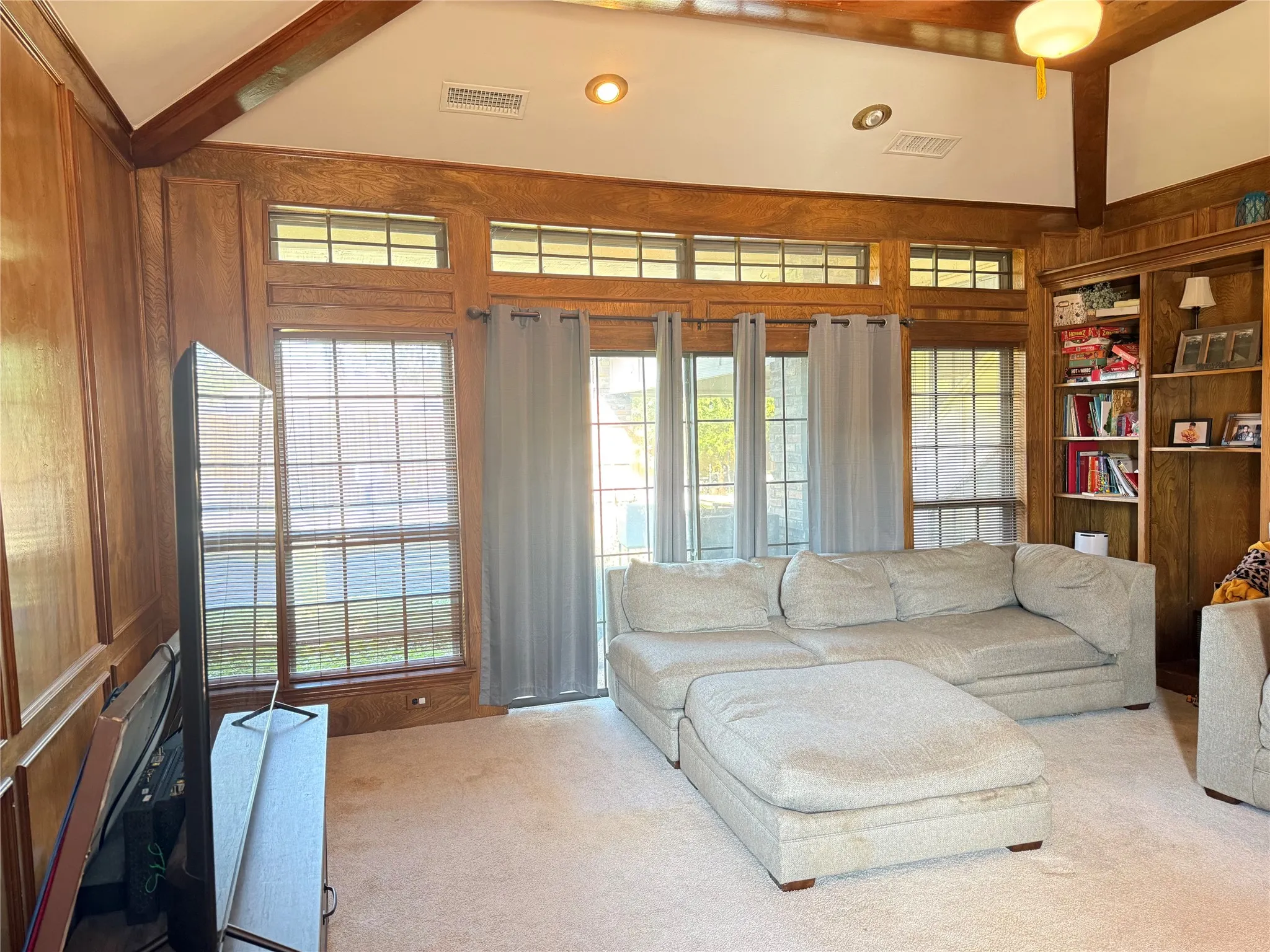 Living room with vaulted ceiling and large windows