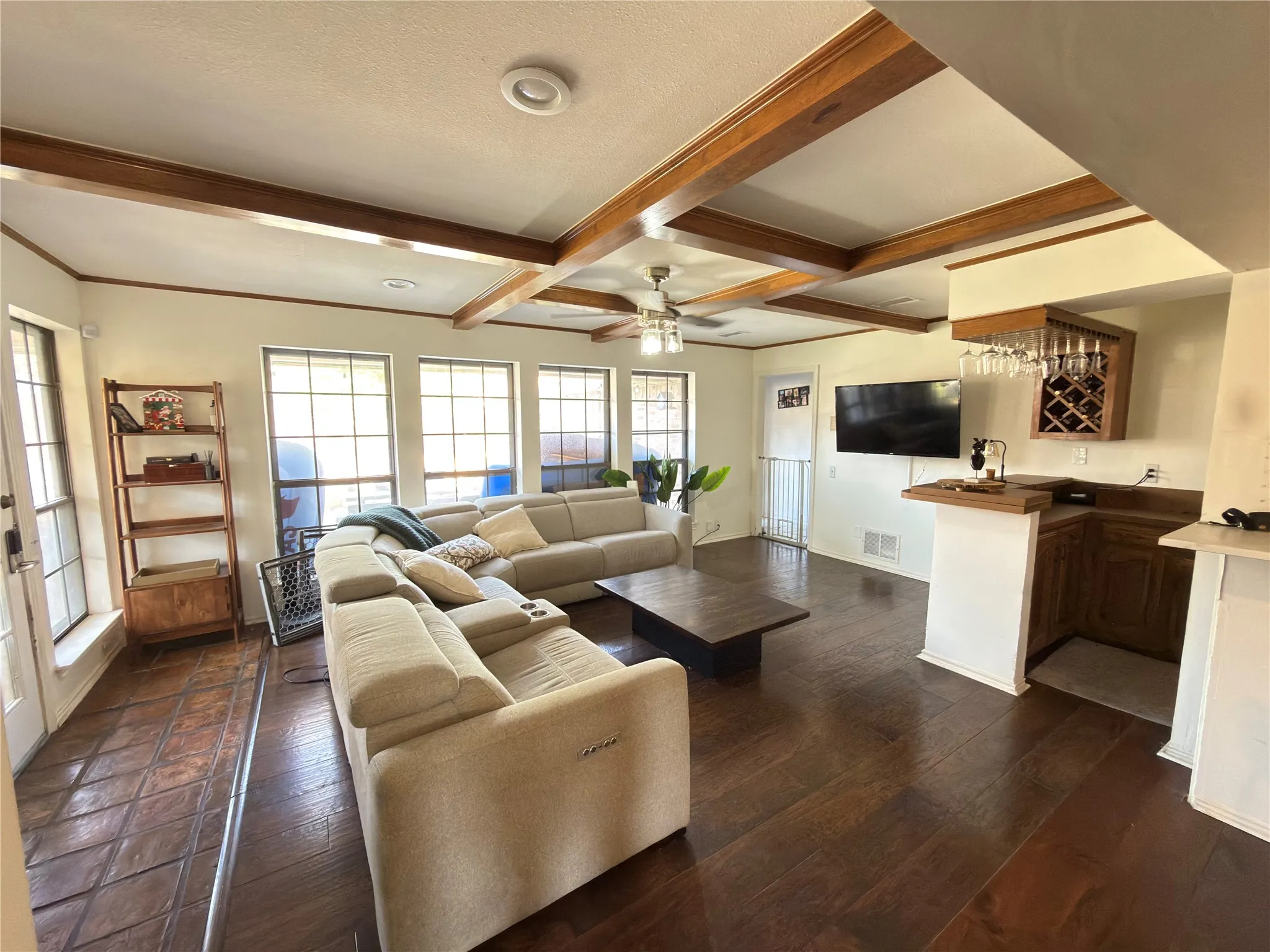 Open concept living room with wood beam ceiling and kitchen view