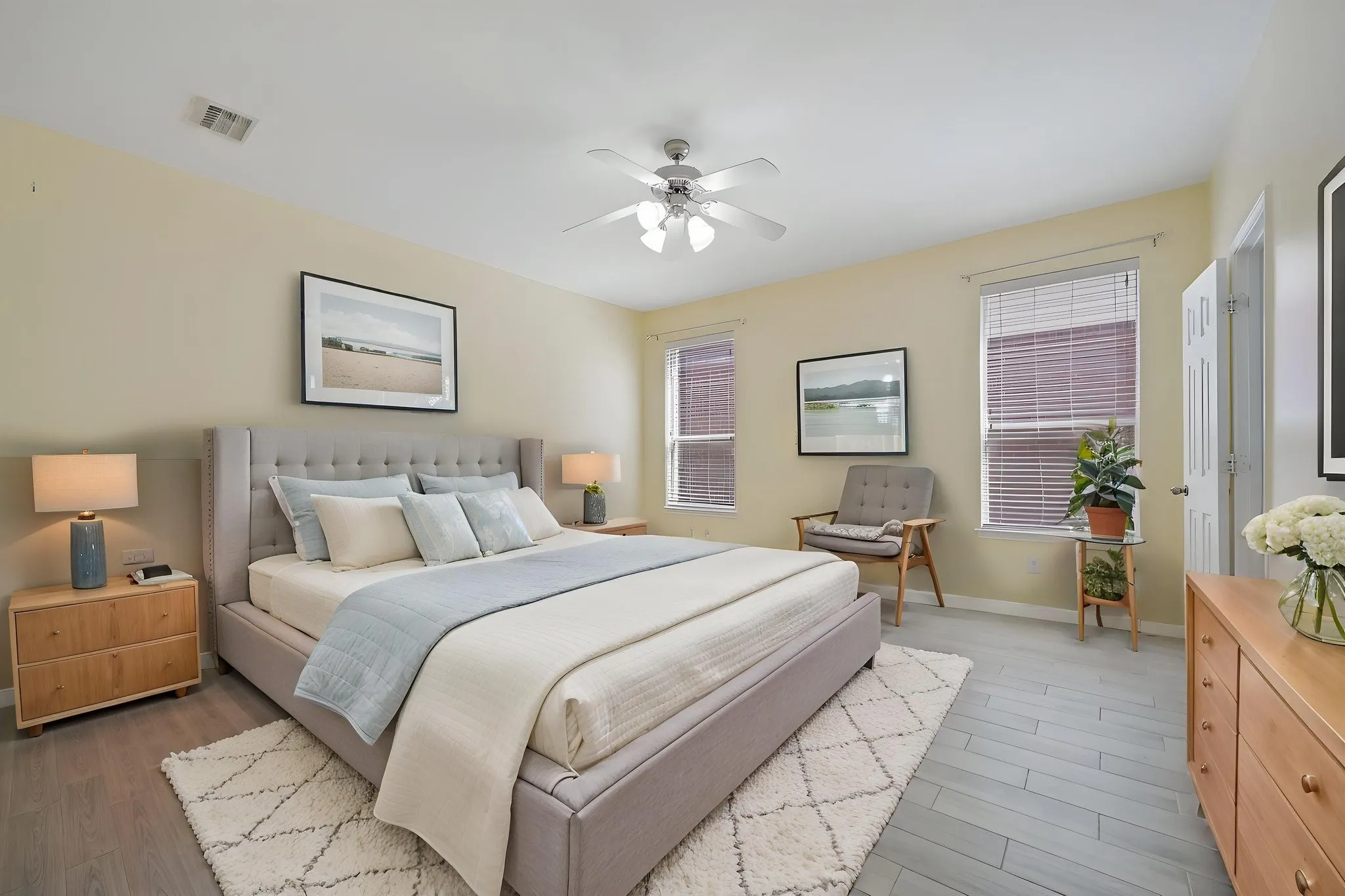 VIRTUALLY STAGED Light-toned walls with multiple windows, a ceiling fan, and wood-finish flooring
