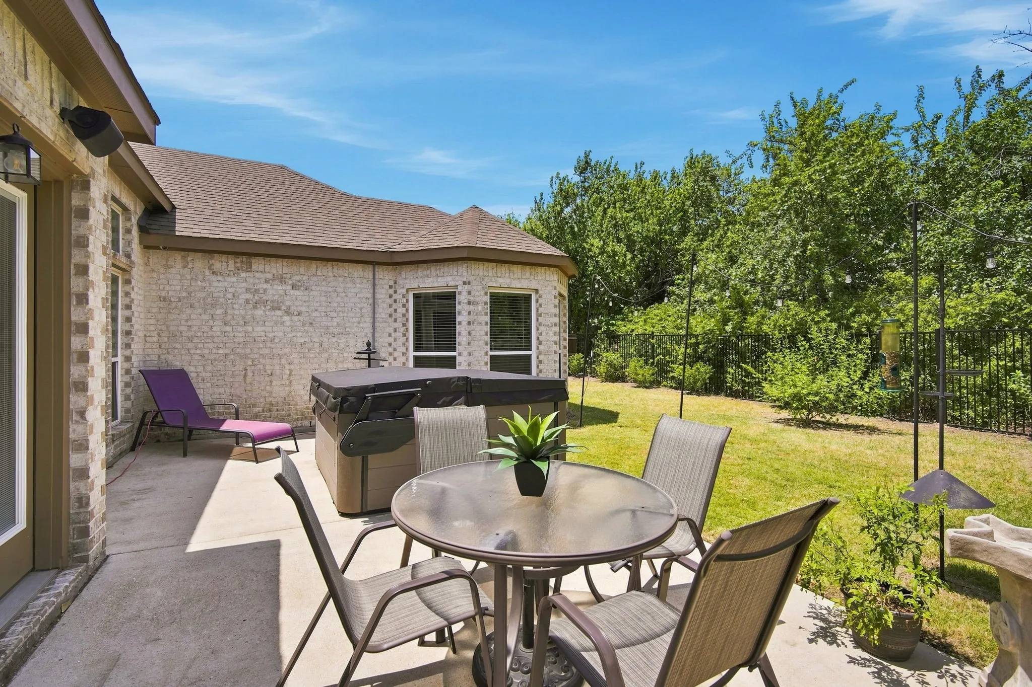 Patio featuring a hot tub installed in 2025 and a private yard backing to mature trees