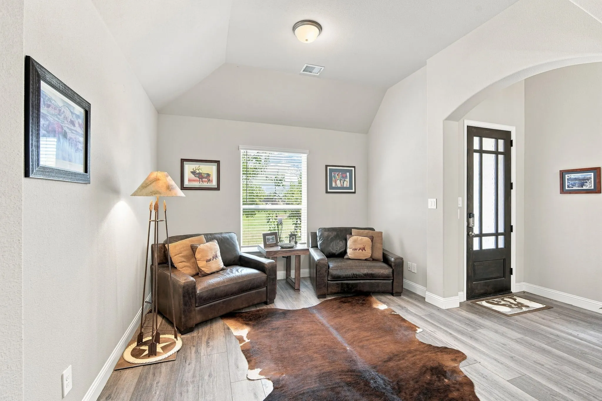 Living room has LVT flooring, arched entry