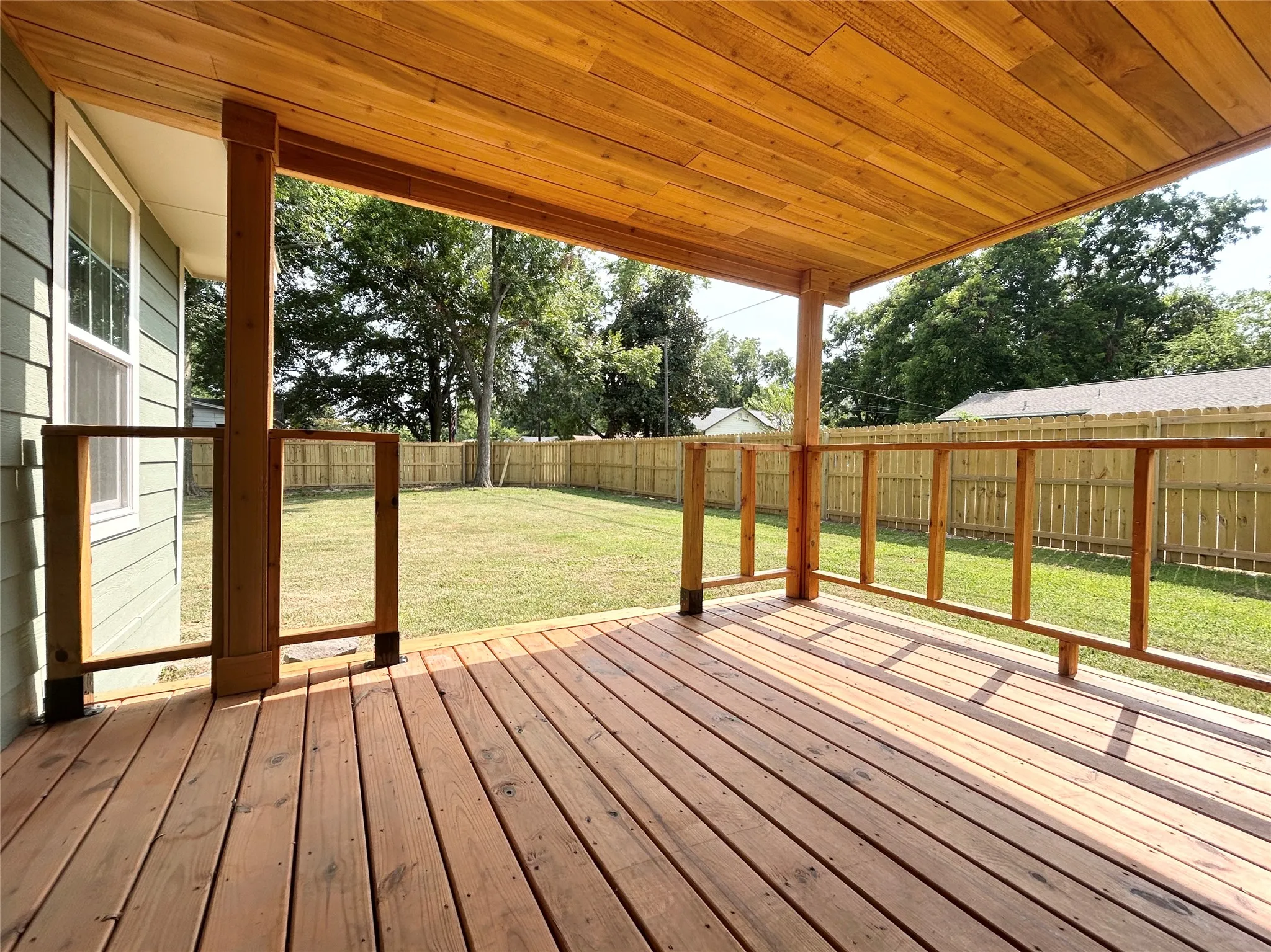 Covered porch overlooking large grassed backyard