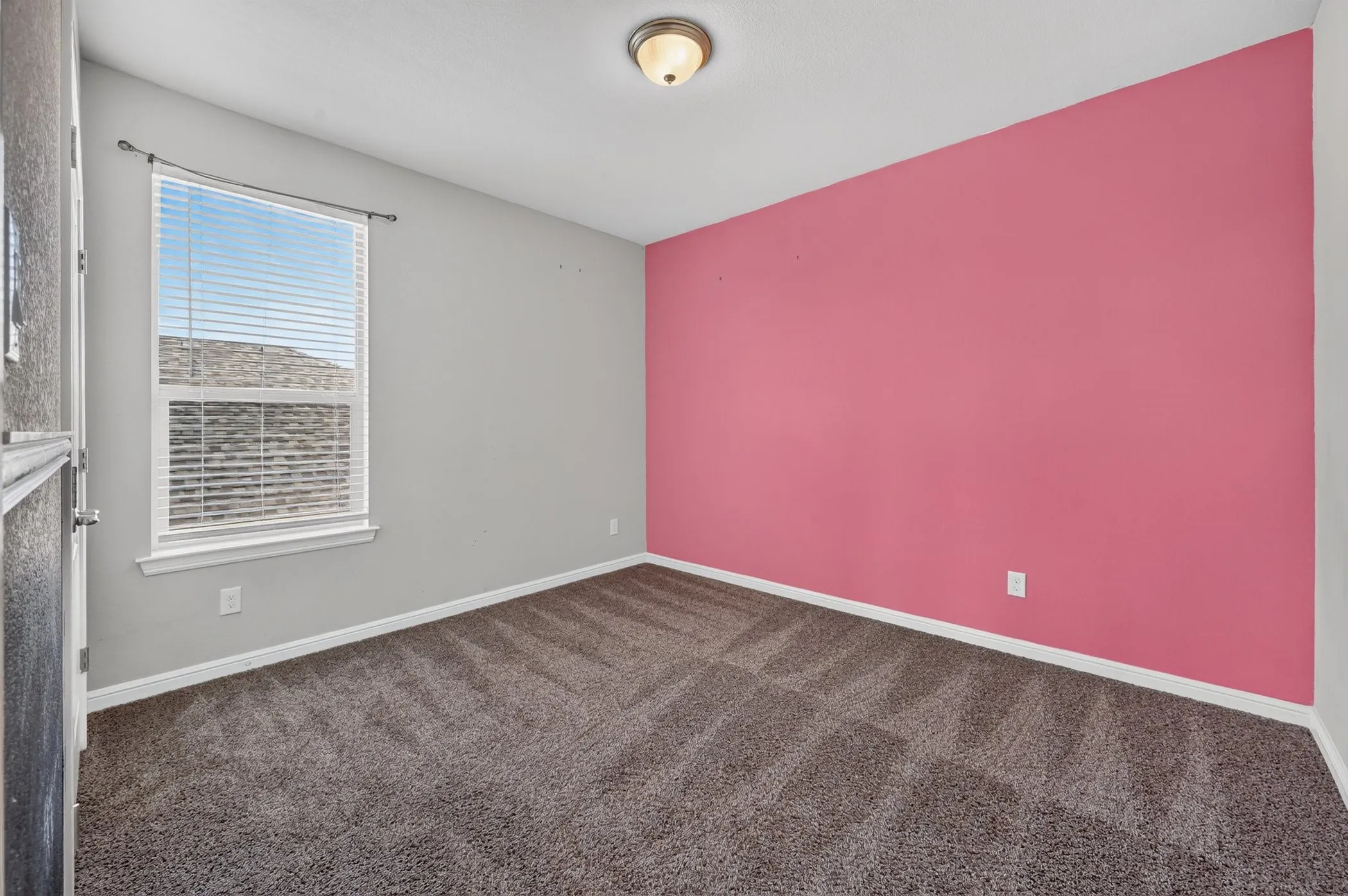 Wall-to-wall carpeting, recessed window with blinds, ceiling-mounted light fixture