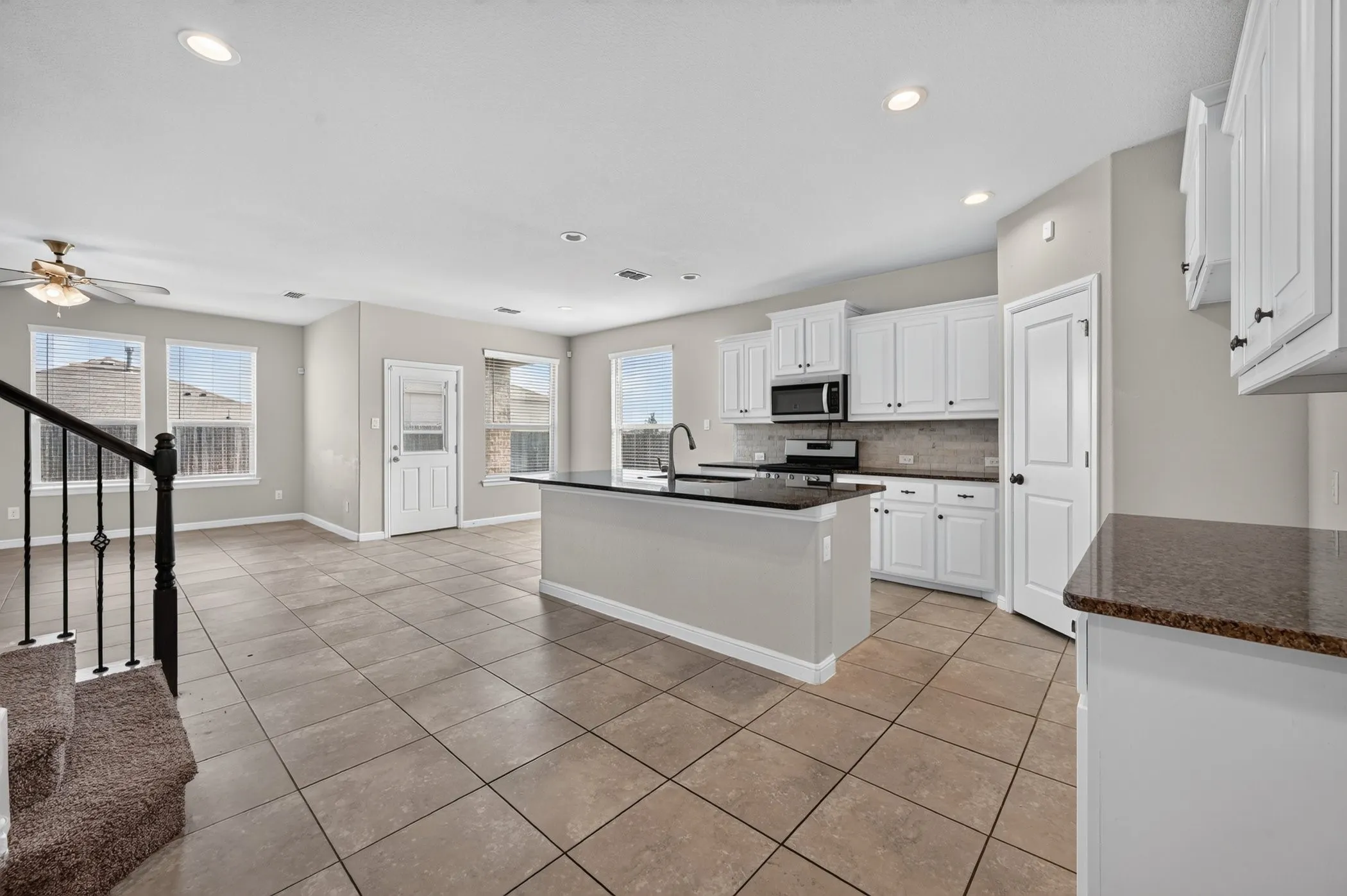 Kitchen featuring an island with a dark countertop, white cabinetry, and stainless steel appliances