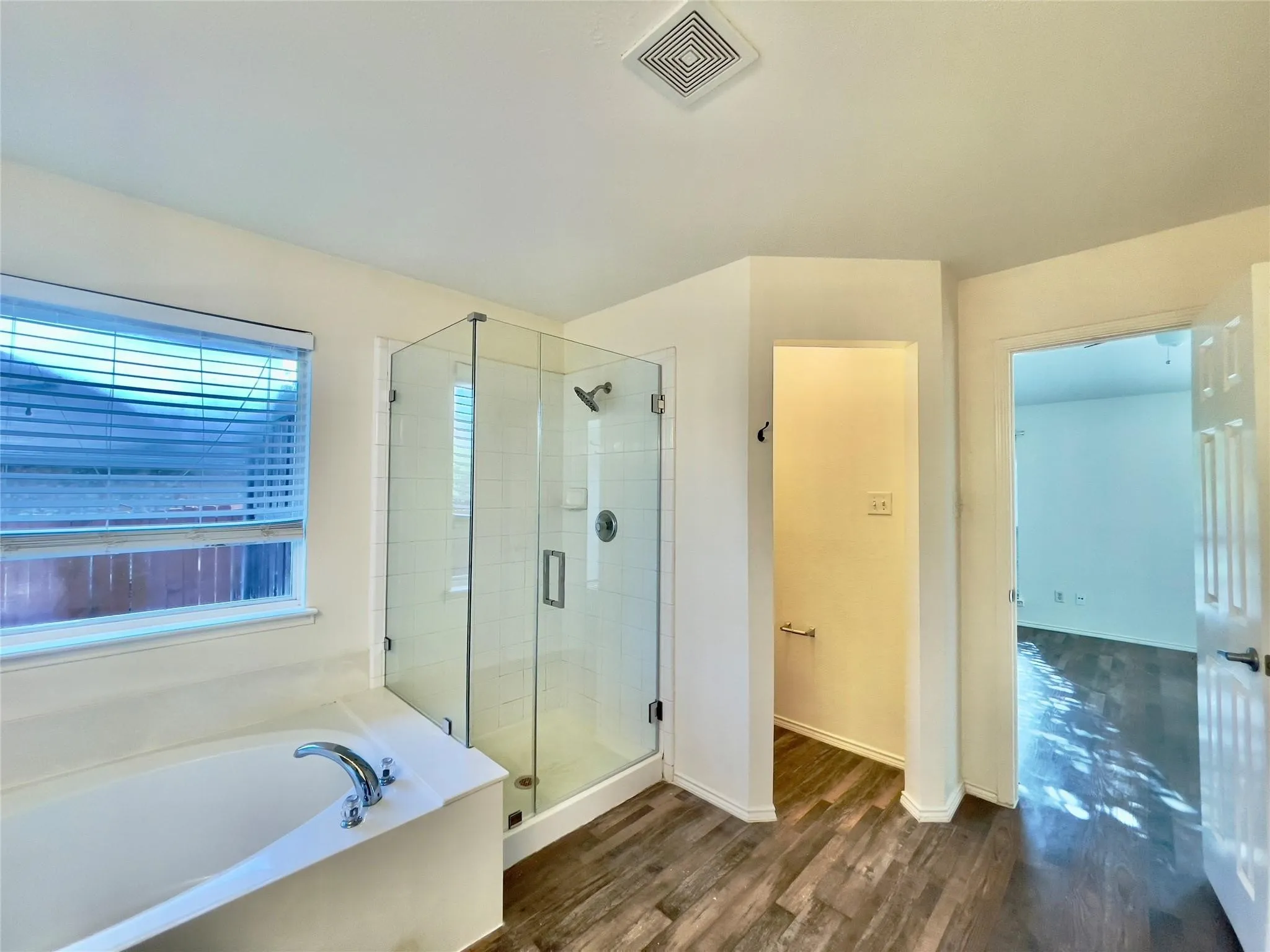 Freestanding shower with glass enclosure, white tile surround, and chrome fixtures