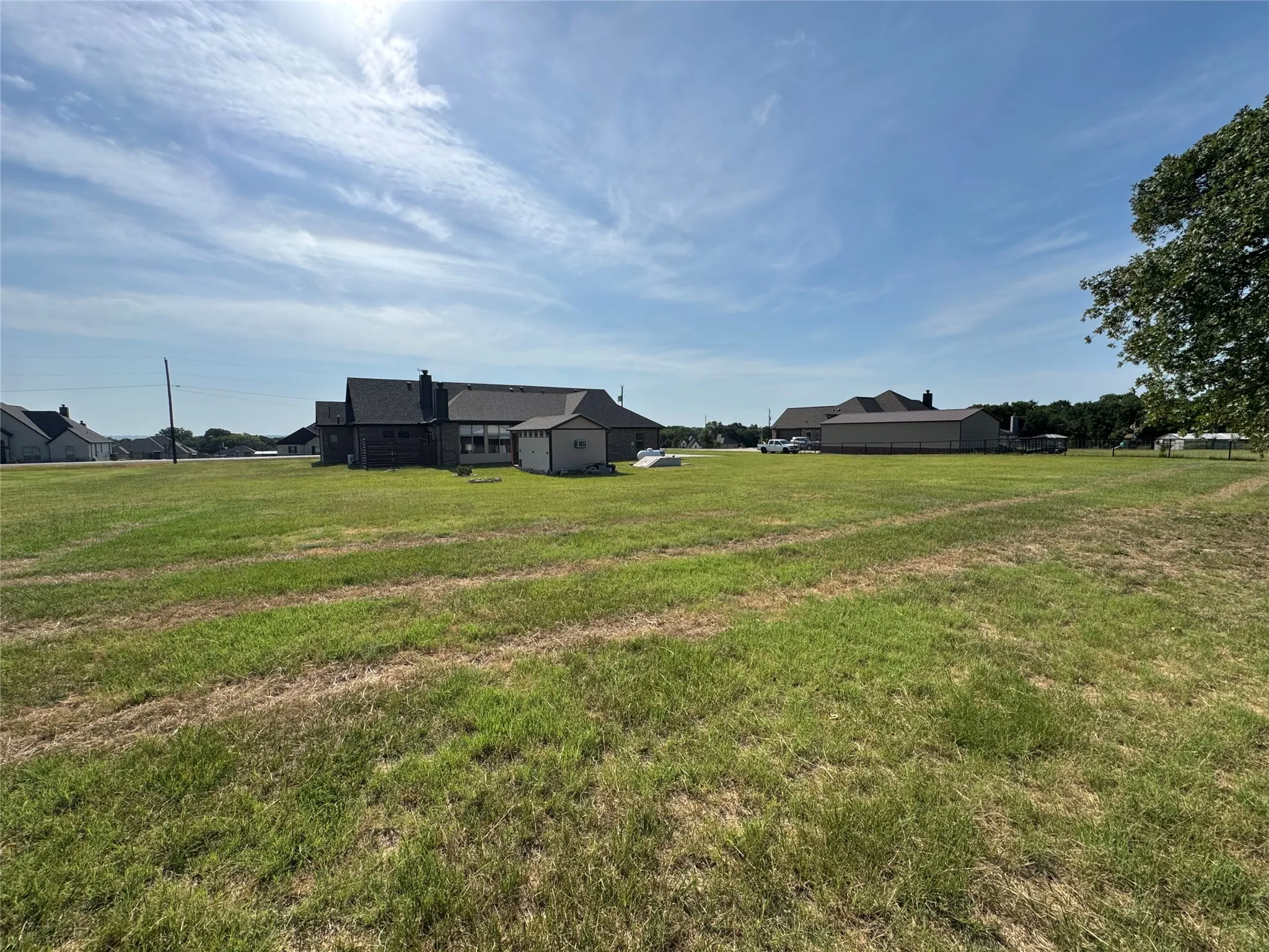 Expansive green space with distant residential structures