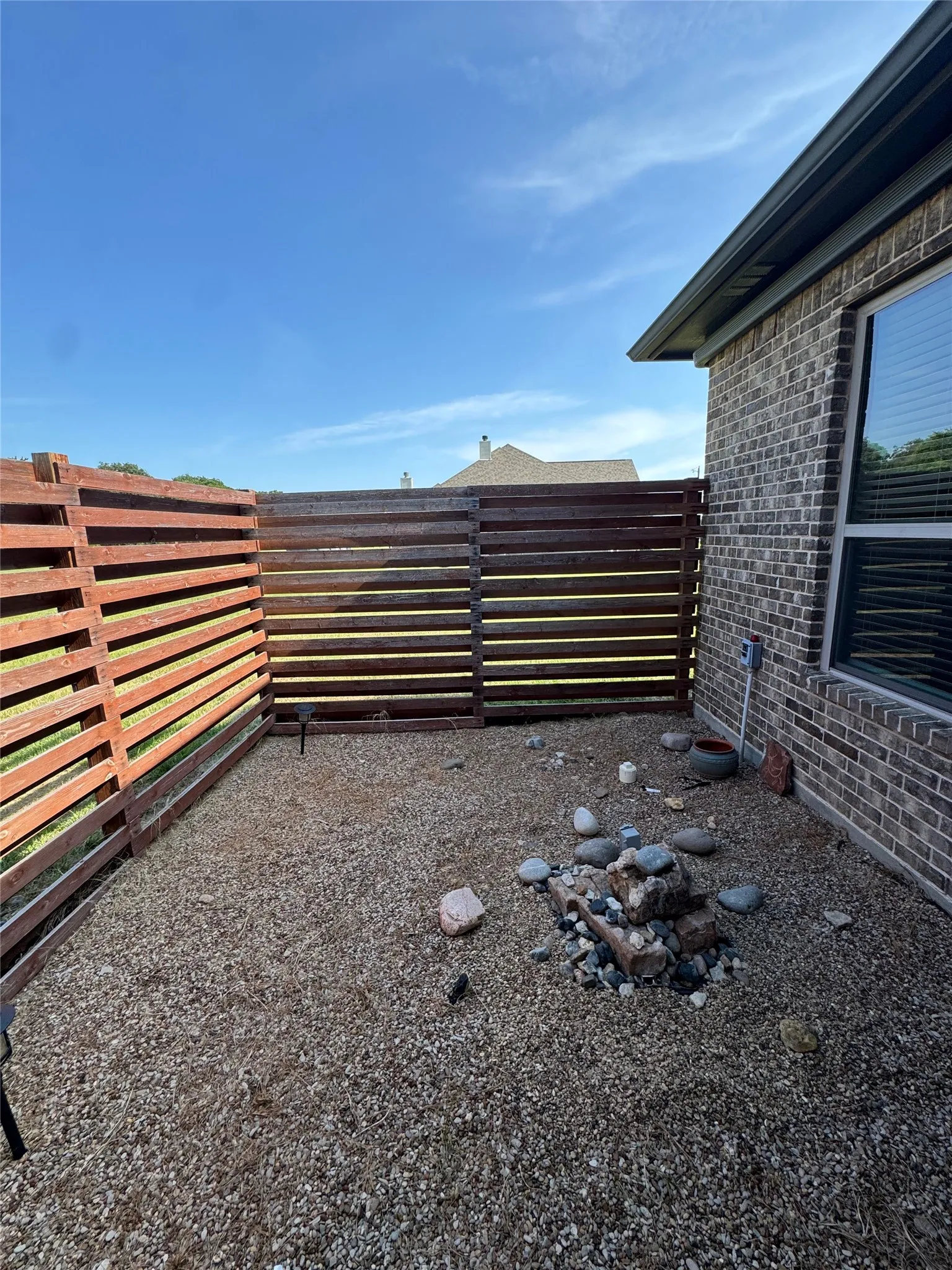 Private outdoor space featuring wood fencing and gravel ground cover
