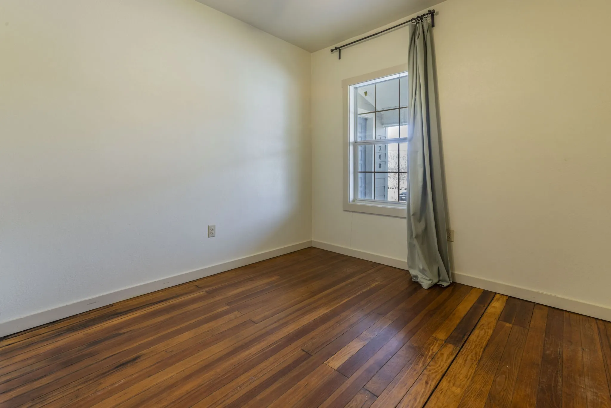 Warm wood-finish flooring complements the neutral wall tones