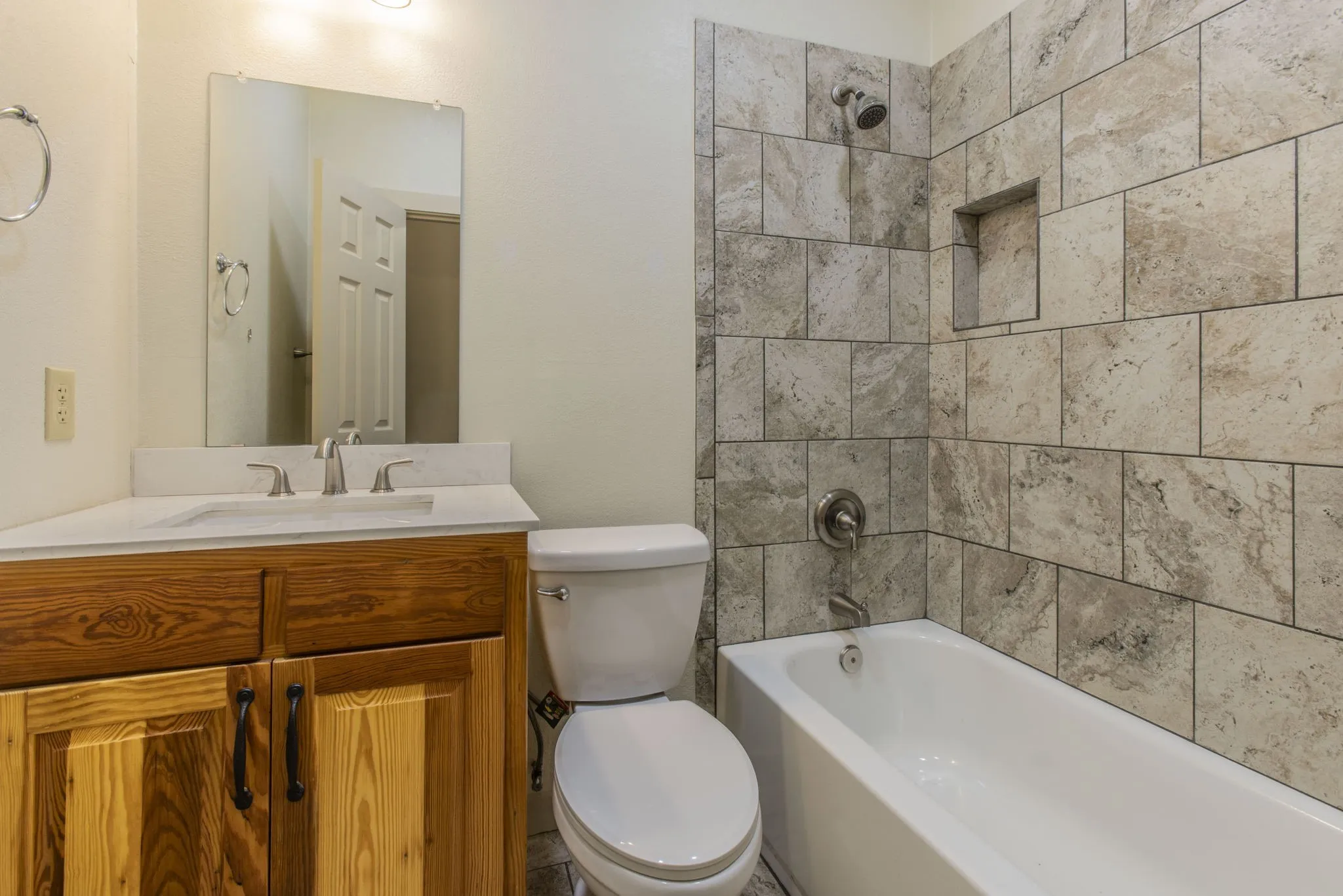 Bathroom featuring a full vanity with wood cabinetry, a white countertop, and a rectangular undermount sink