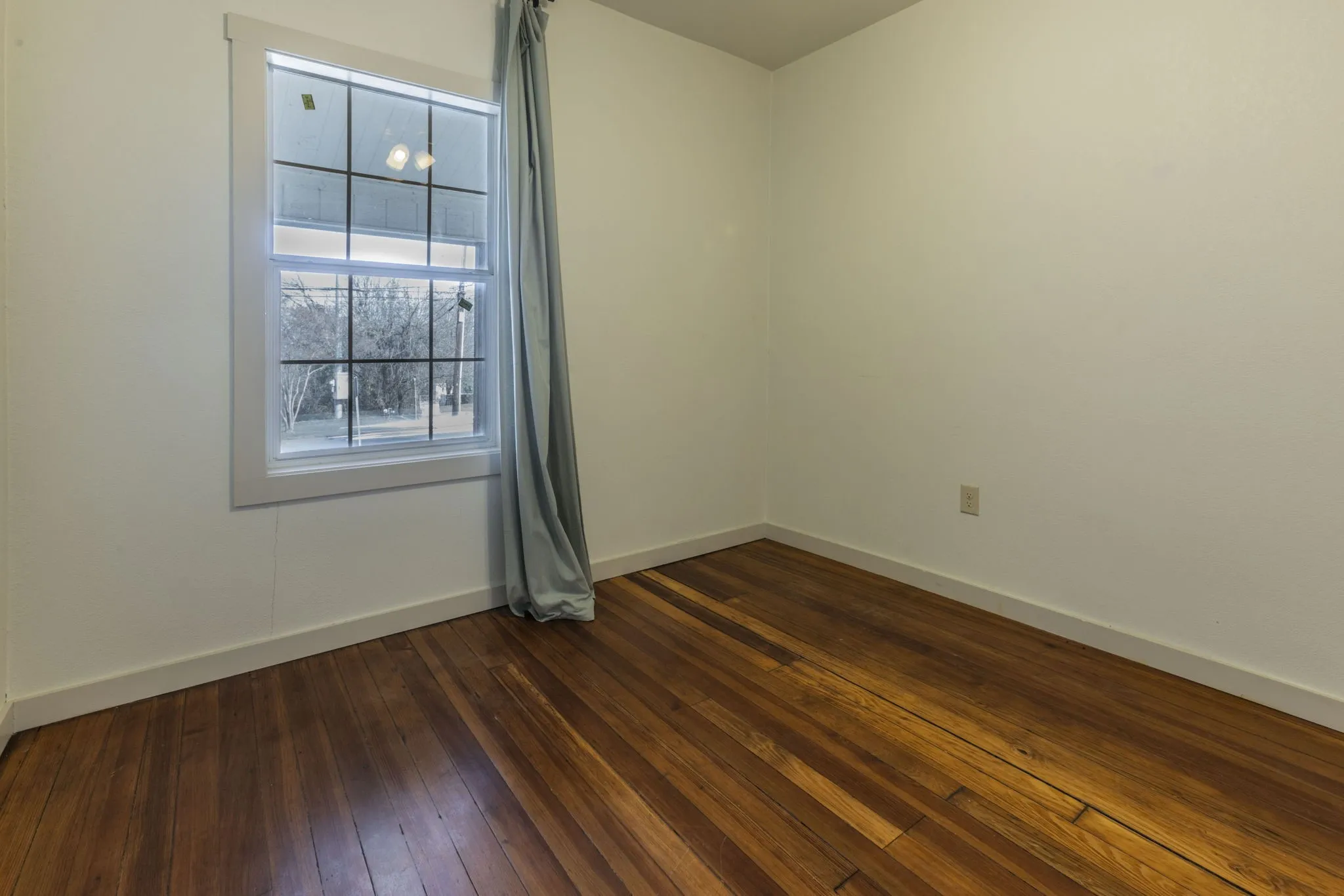 Room featuring wood flooring and white painted walls